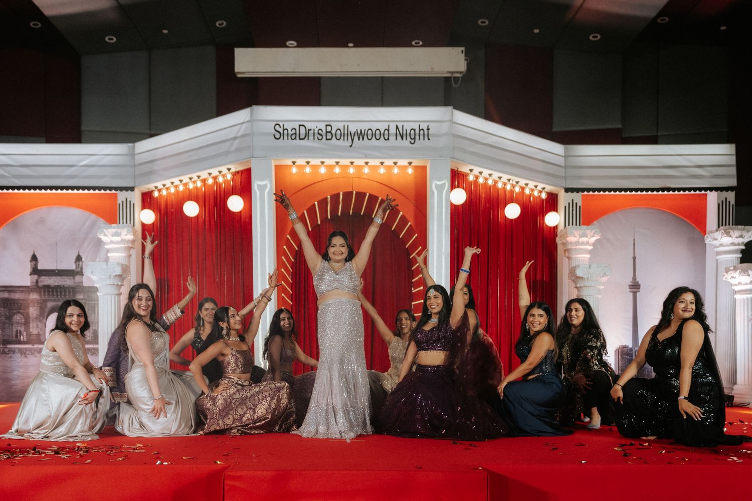 Indoor celebration with red curtains and decorative lighting.
