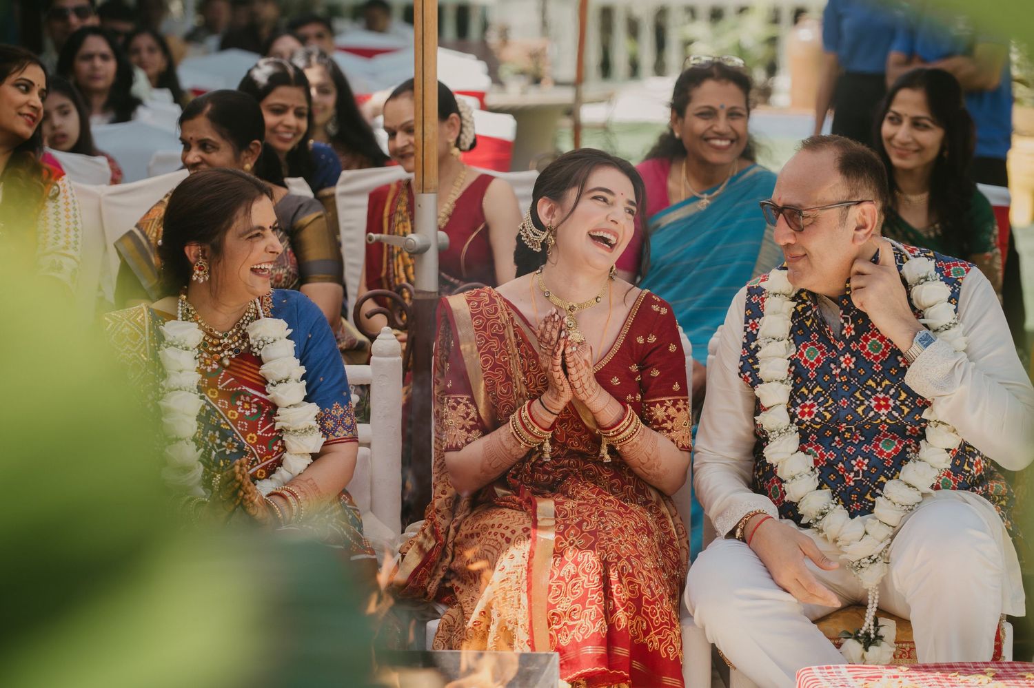 A group of friends share joyful laughter and celebrations during an outdoor gathering in bright daylight.