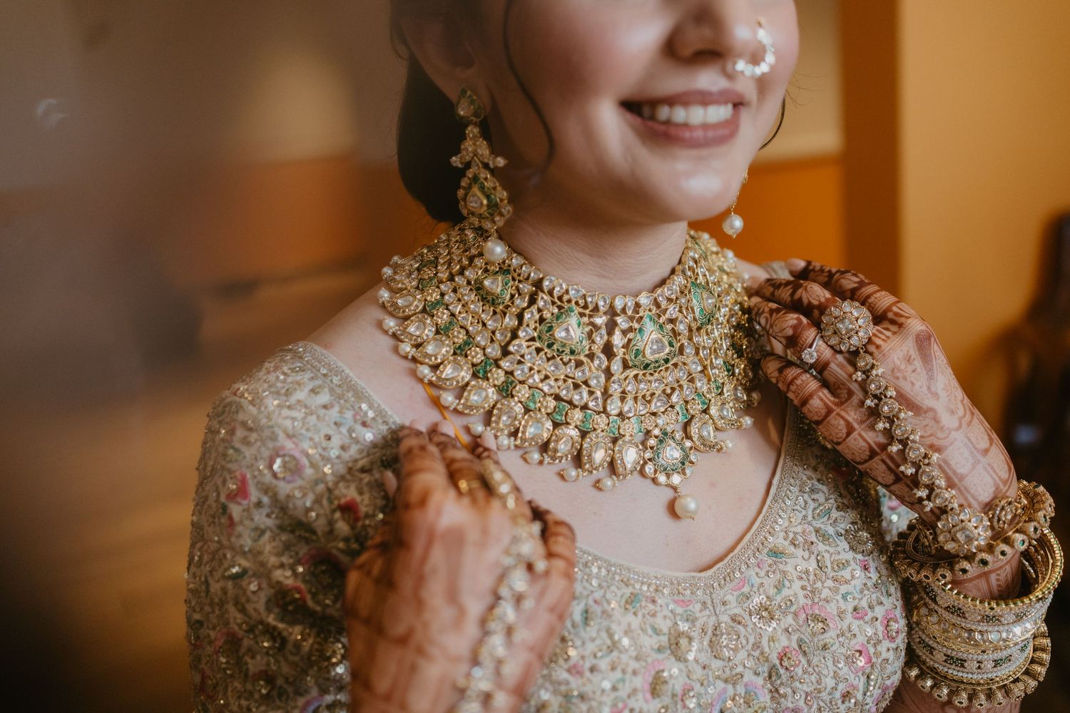 Traditional Indian bride adorned in gold and beaded jewelry shows intricate details of wedding attire and accessories.