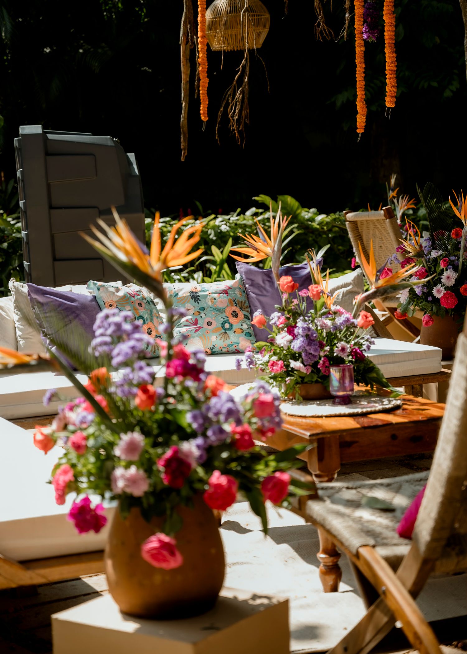 Colorful floral centerpieces with tropical flowers and bright blooms decorate wooden tables.