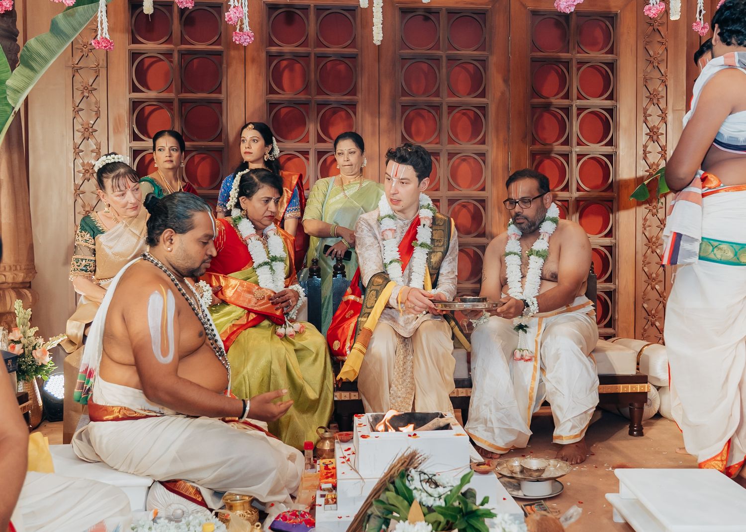 Wedding celebration with guests seated at decorated tables in an ornate indoor venue.