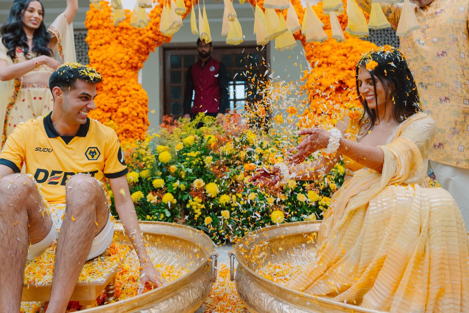 Festive celebration with marigold garlands and yellow-themed decor at an Indian wedding.