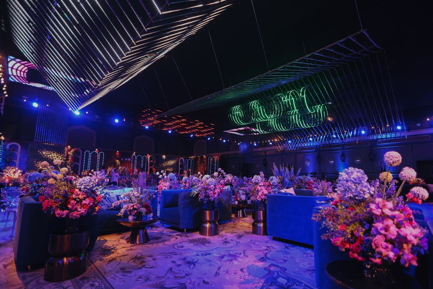 Concert stage illuminated with vibrant blue and pink lighting creates a dynamic atmosphere for a nighttime performance.