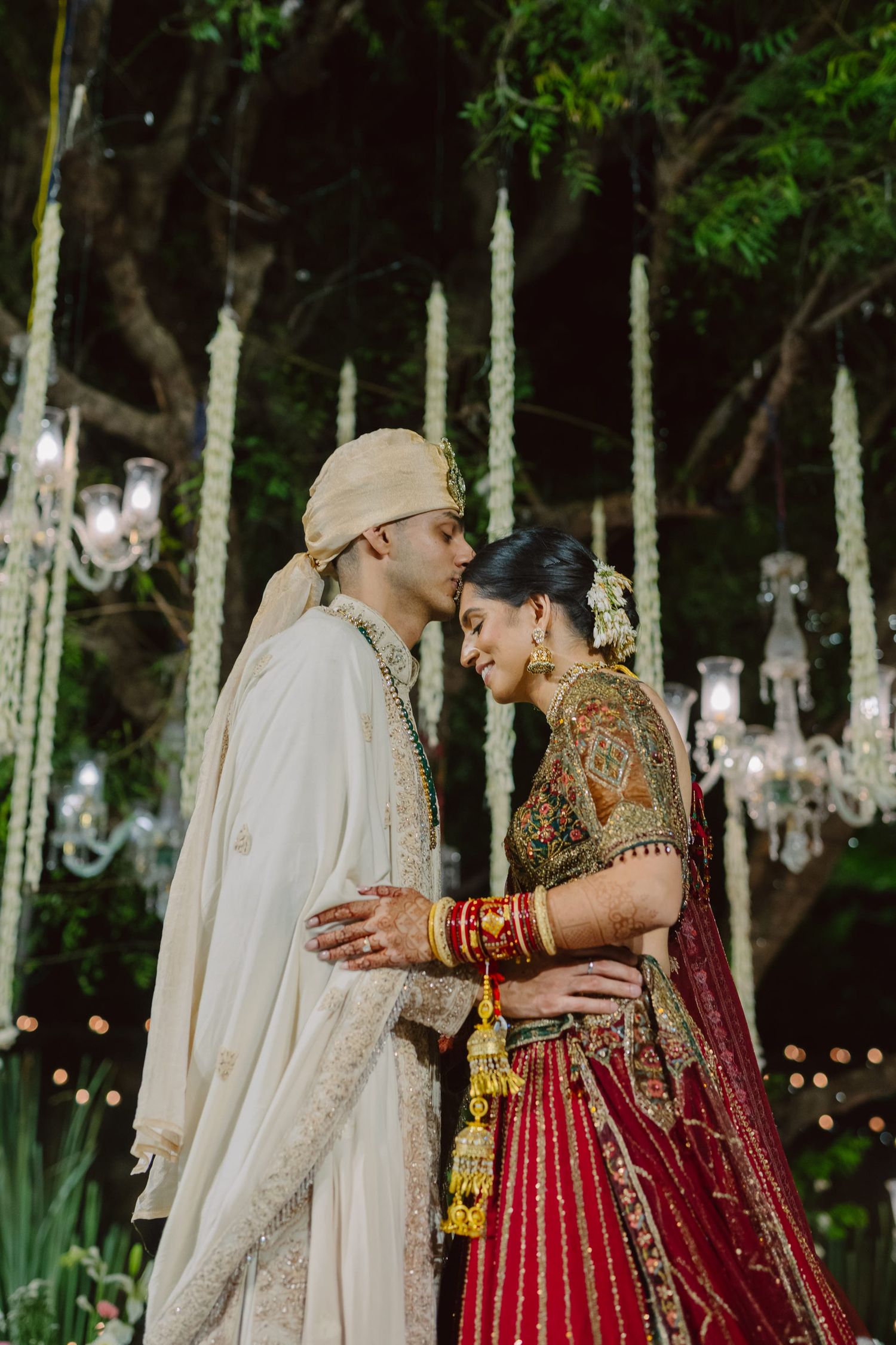 Romantic nighttime wedding photography with string lights illuminating a garden setting.