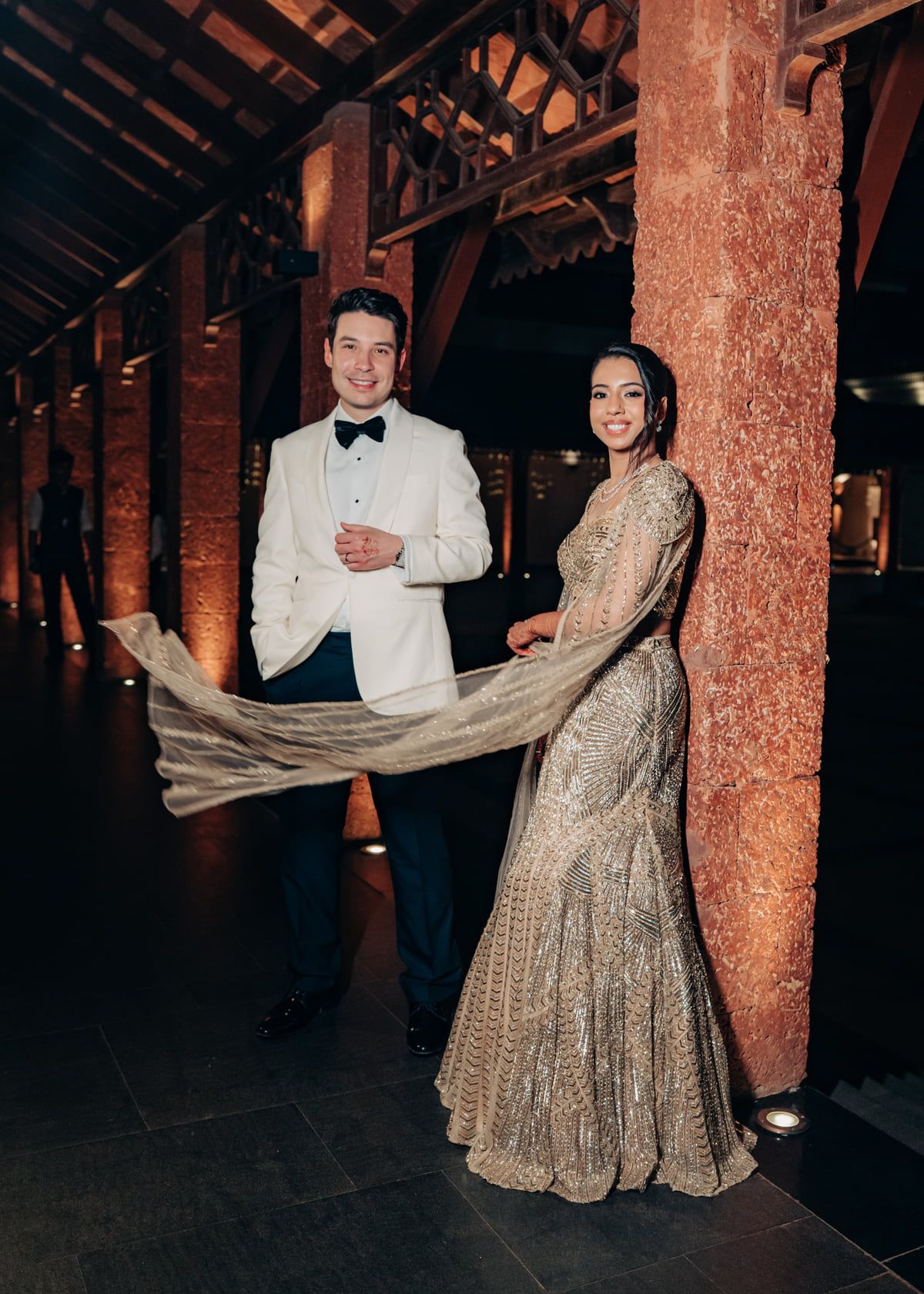 A couple performing their first dance in an elegant venue with wooden architectural details.