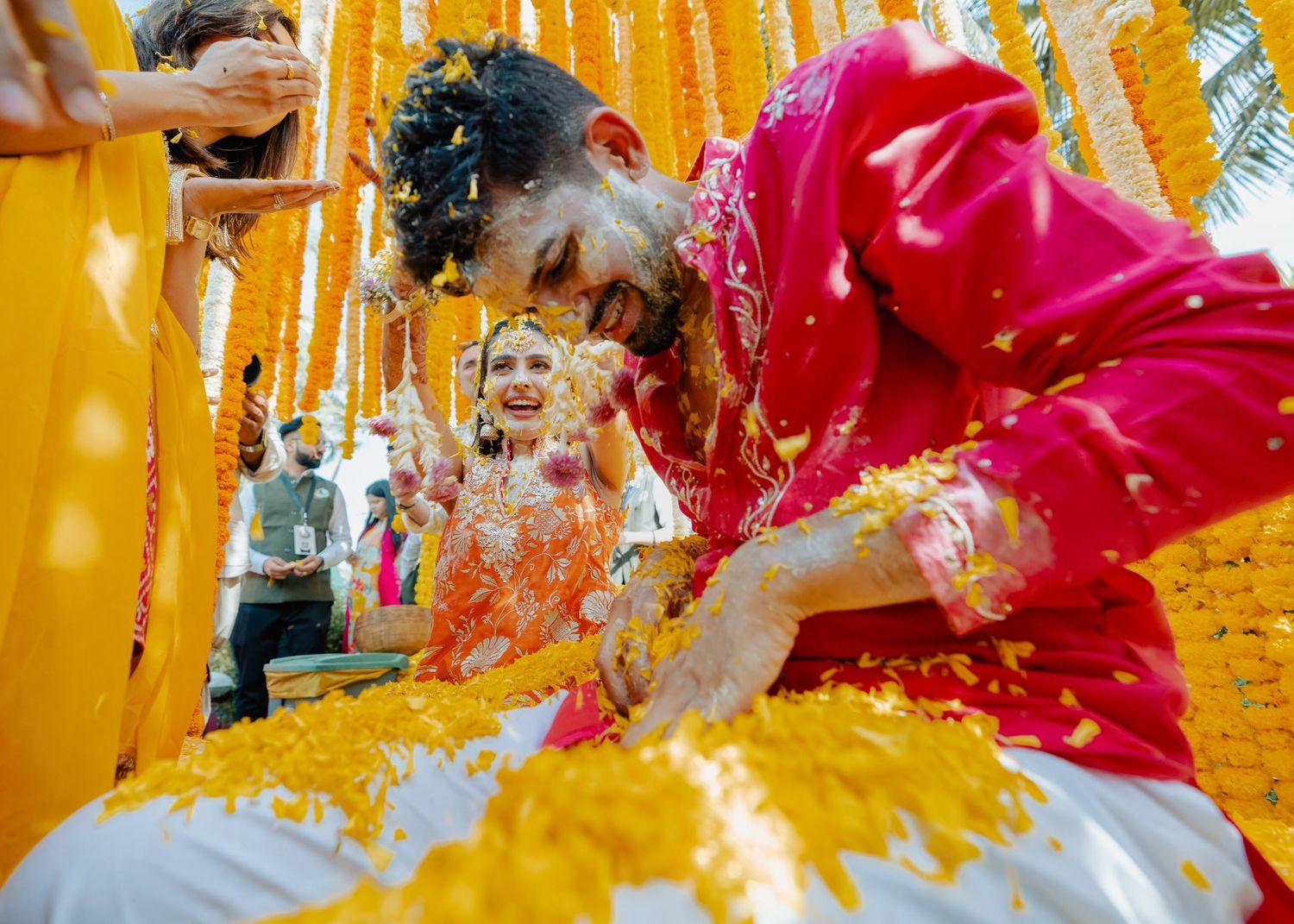 Traditional Indian Haldi ceremony with yellow turmeric paste and vibrant orange and red decorations during wedding celebrations.