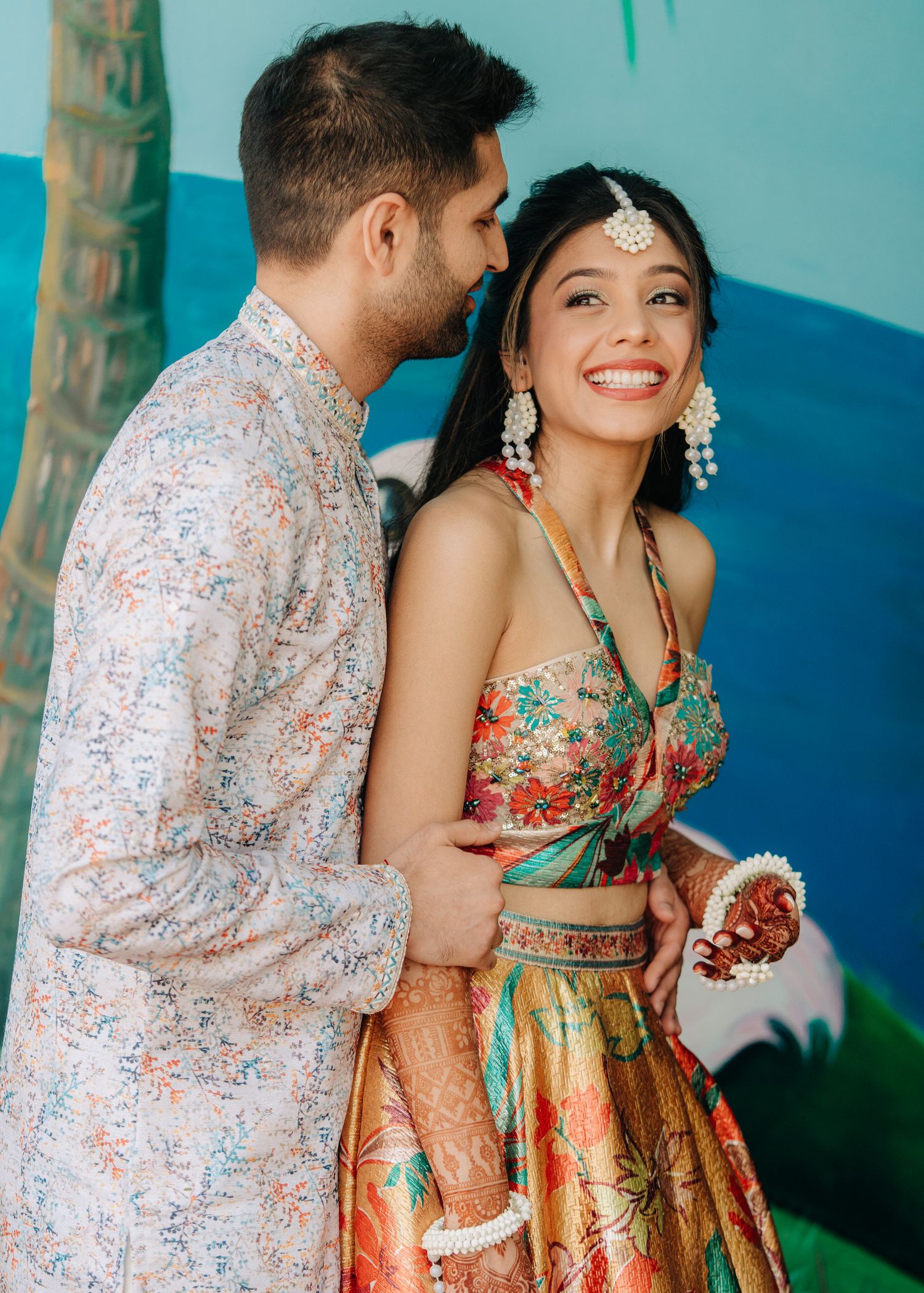 Couple in traditional Indian wedding attire share intimate moments against turquoise backdrop in four sequential photos.