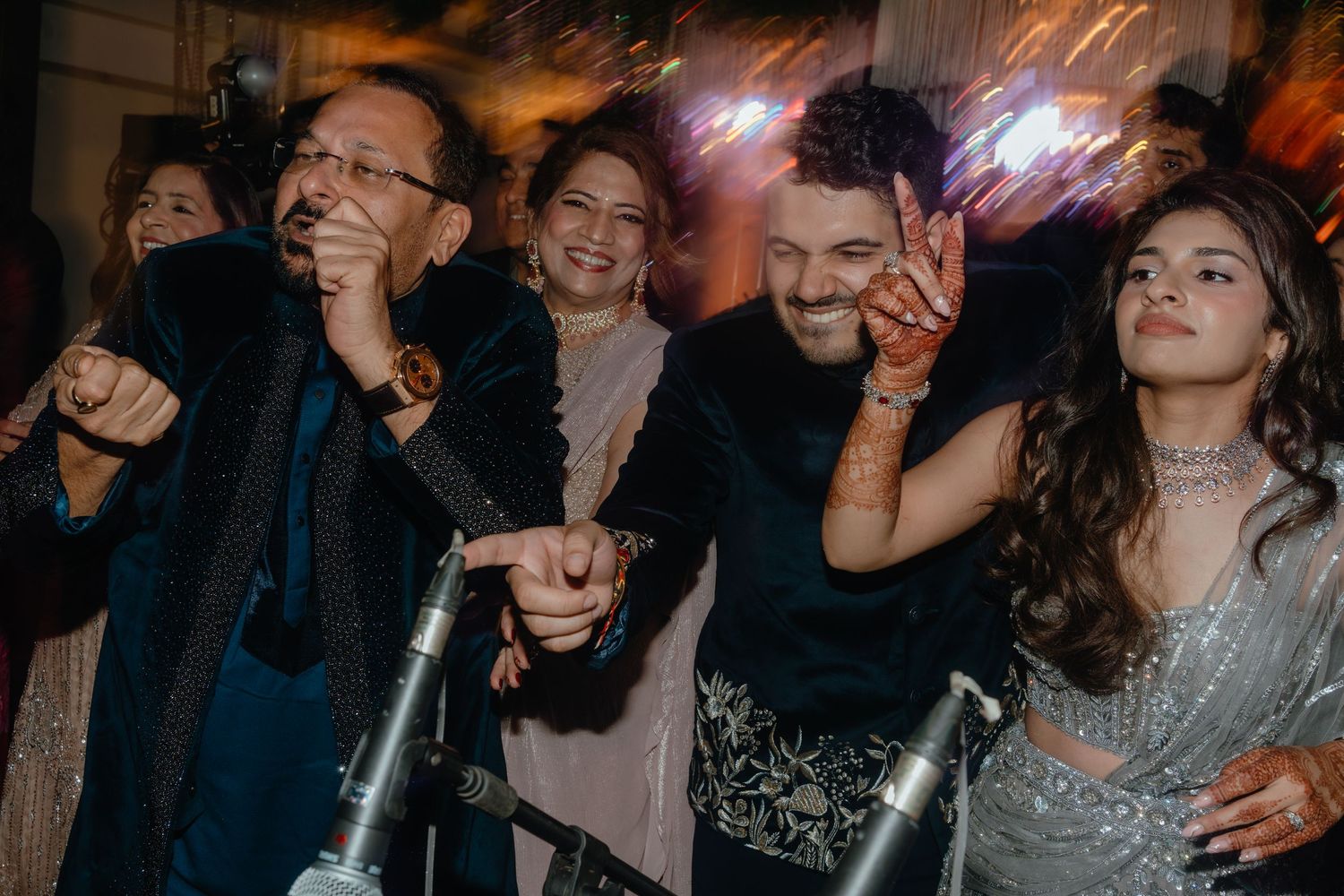 A crowd of people dancing and celebrating at a lively party with colorful lighting and festive atmosphere.