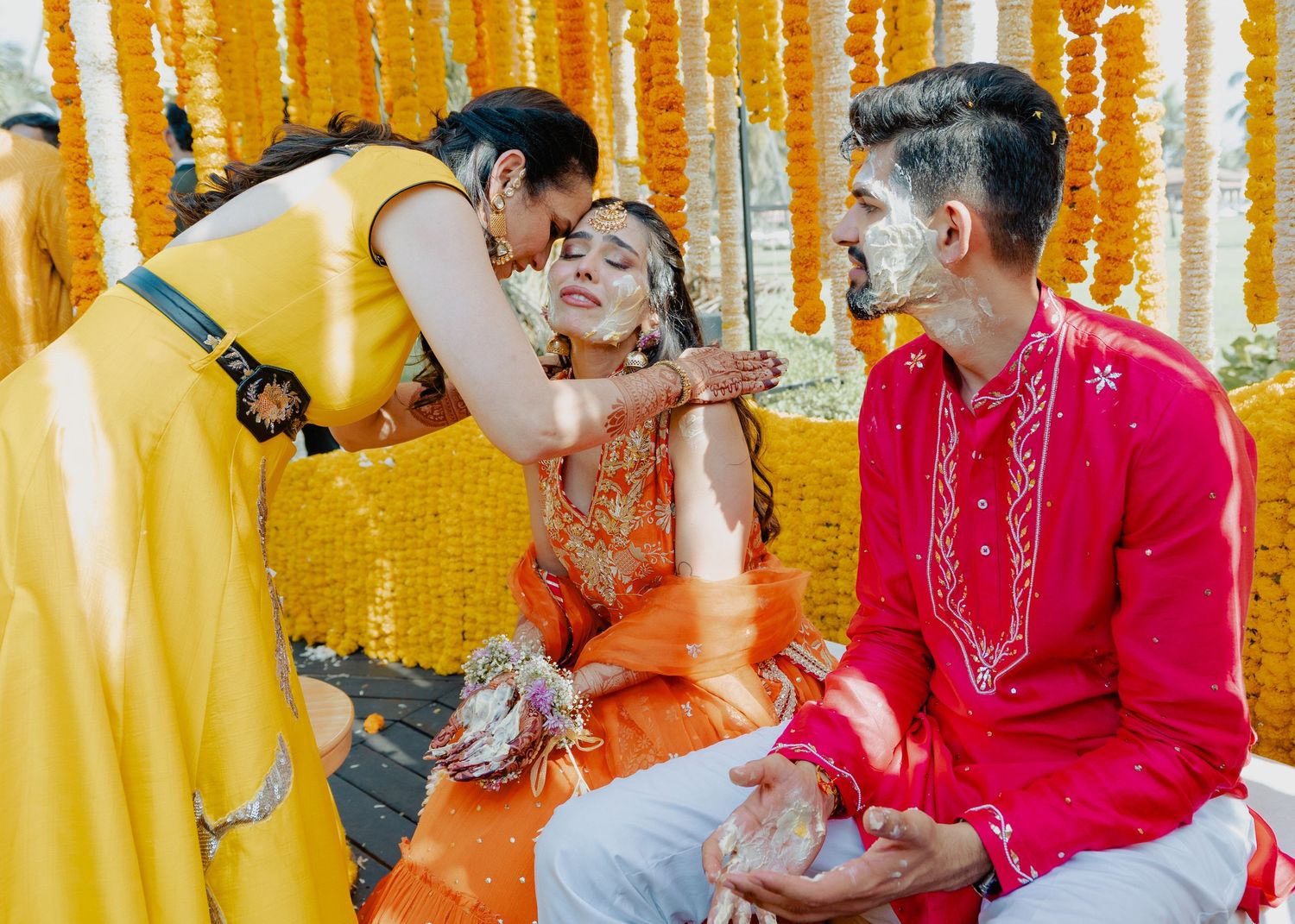 Traditional Indian wedding ritual taking place under bright orange marigold garland decorations.