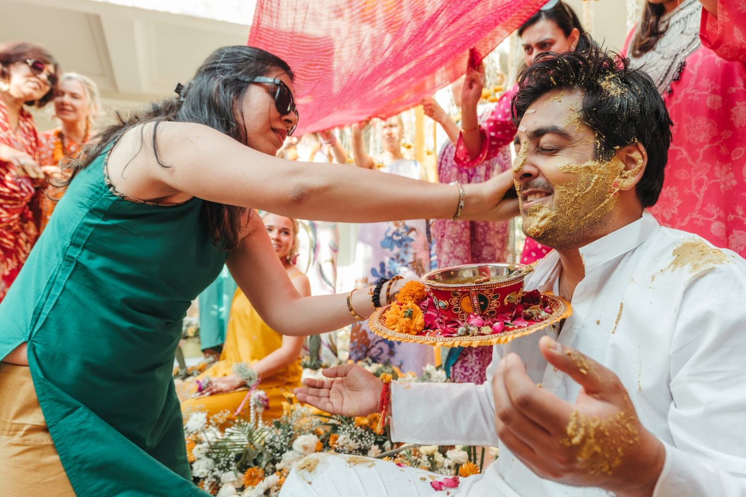 Celebratory moment with guests throwing pink flower petals during a festive ceremony.