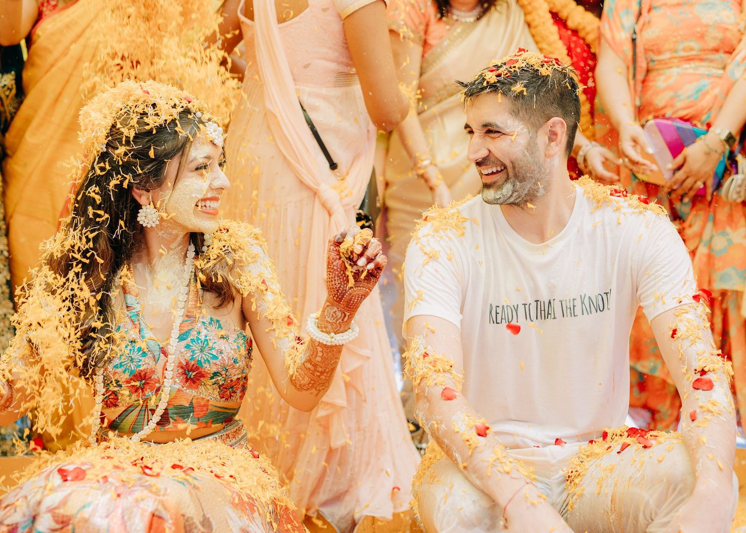 People celebrating with colorful glitter and confetti in golden sunlight creating a joyful party atmosphere.