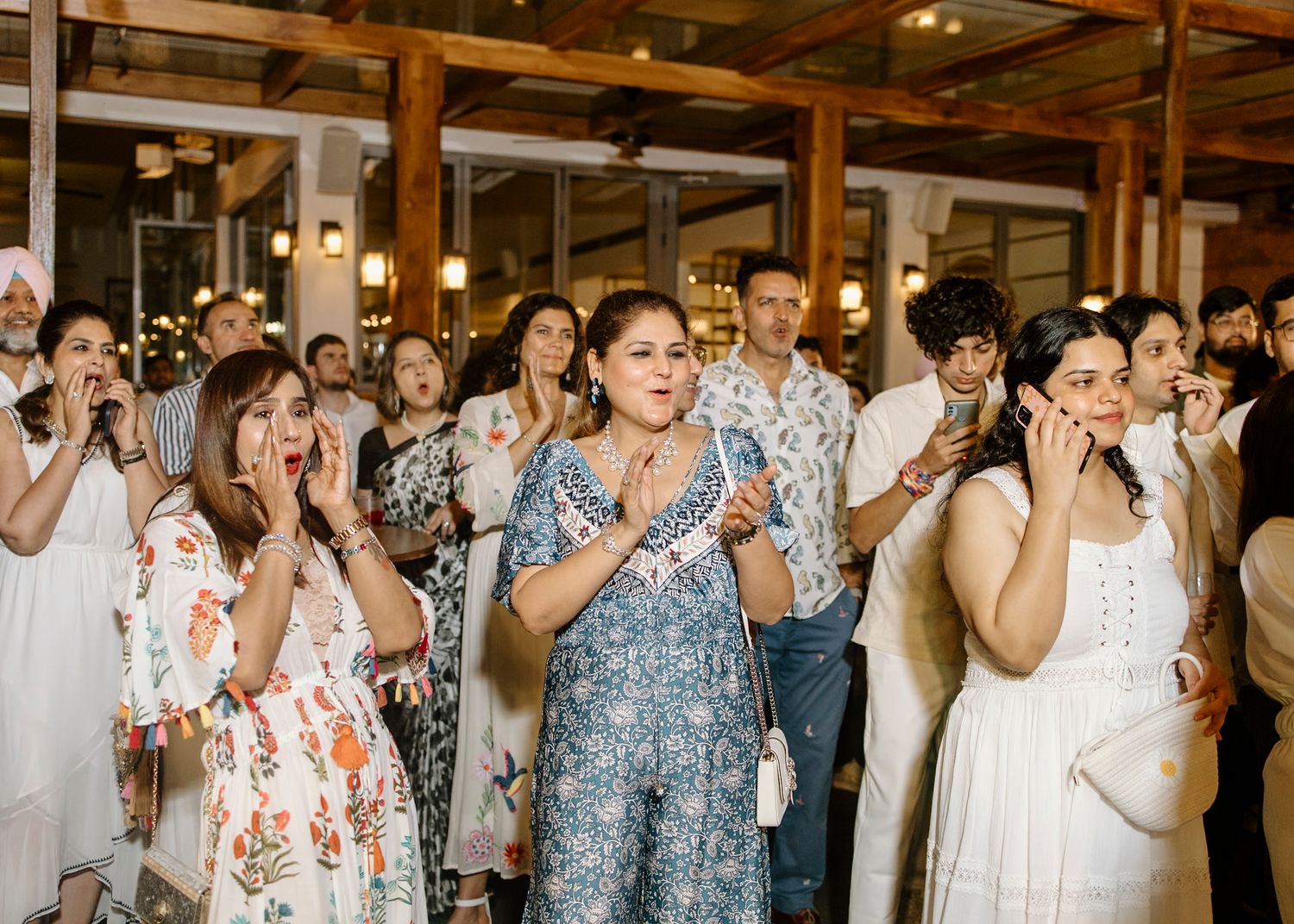 Wedding party dances in a line during a festive indoor celebration.