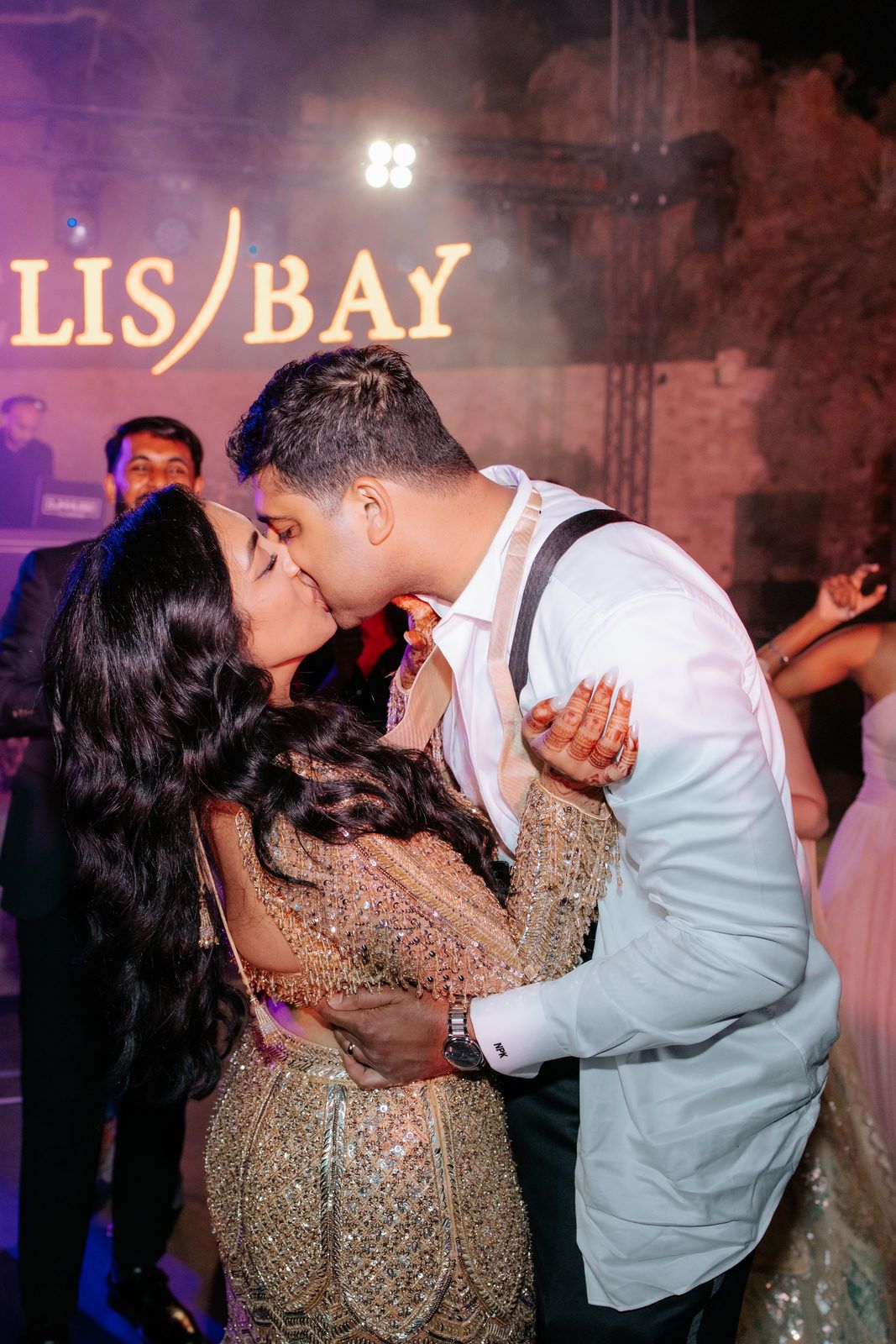 Couple sharing a romantic kiss on the dance floor at LIS BAY venue during their wedding reception.