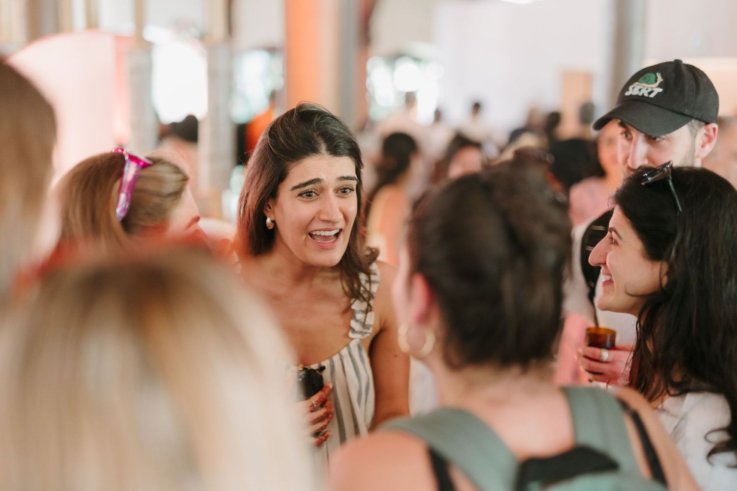 A blurred party crowd dancing and having fun at a celebration event indoors.