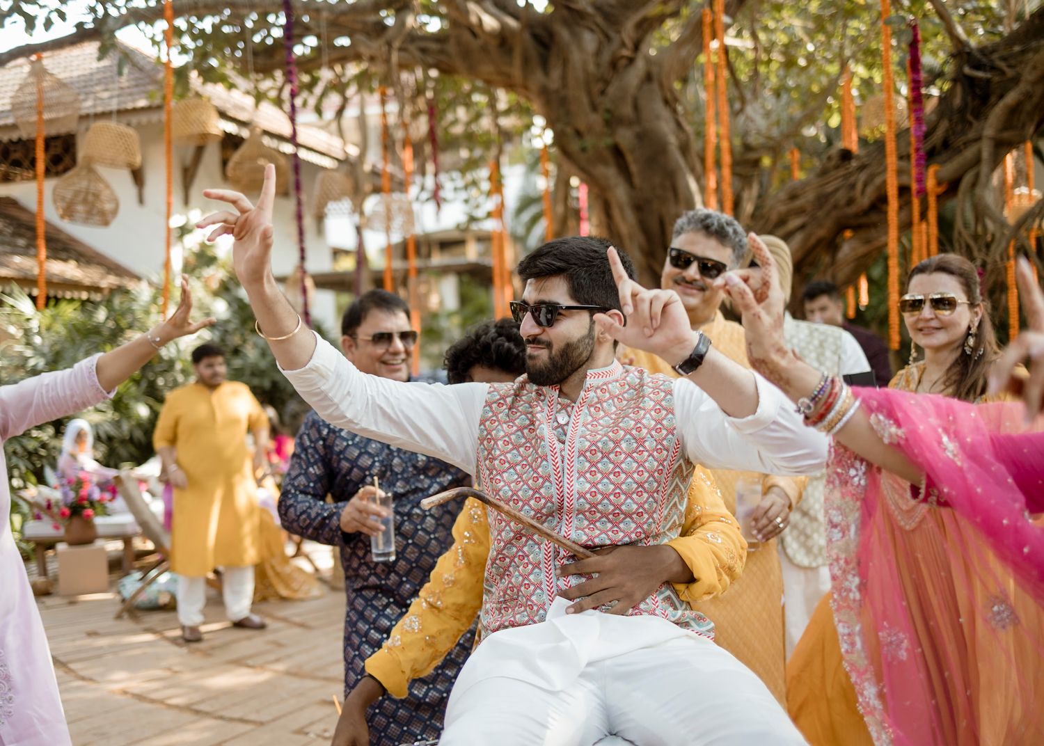Celebratory dance at an Indian wedding with guests in traditional attire.