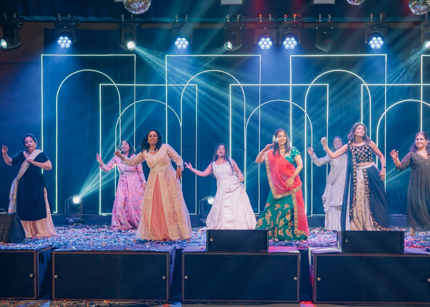 Choreographed dance performance on stage with colorful traditional outfits and dramatic lighting.
