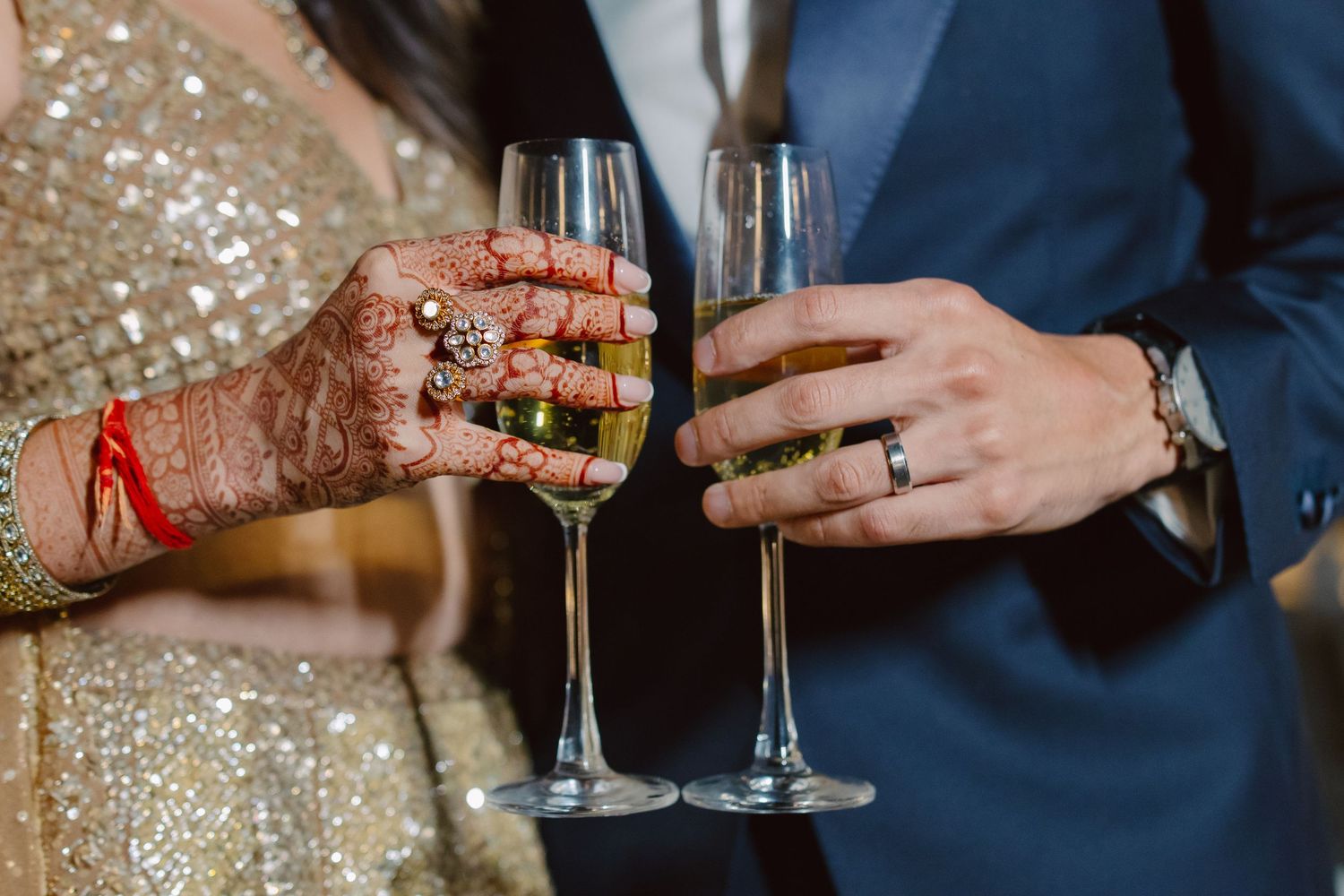 Close up of hands holding champagne glasses during wedding toast.