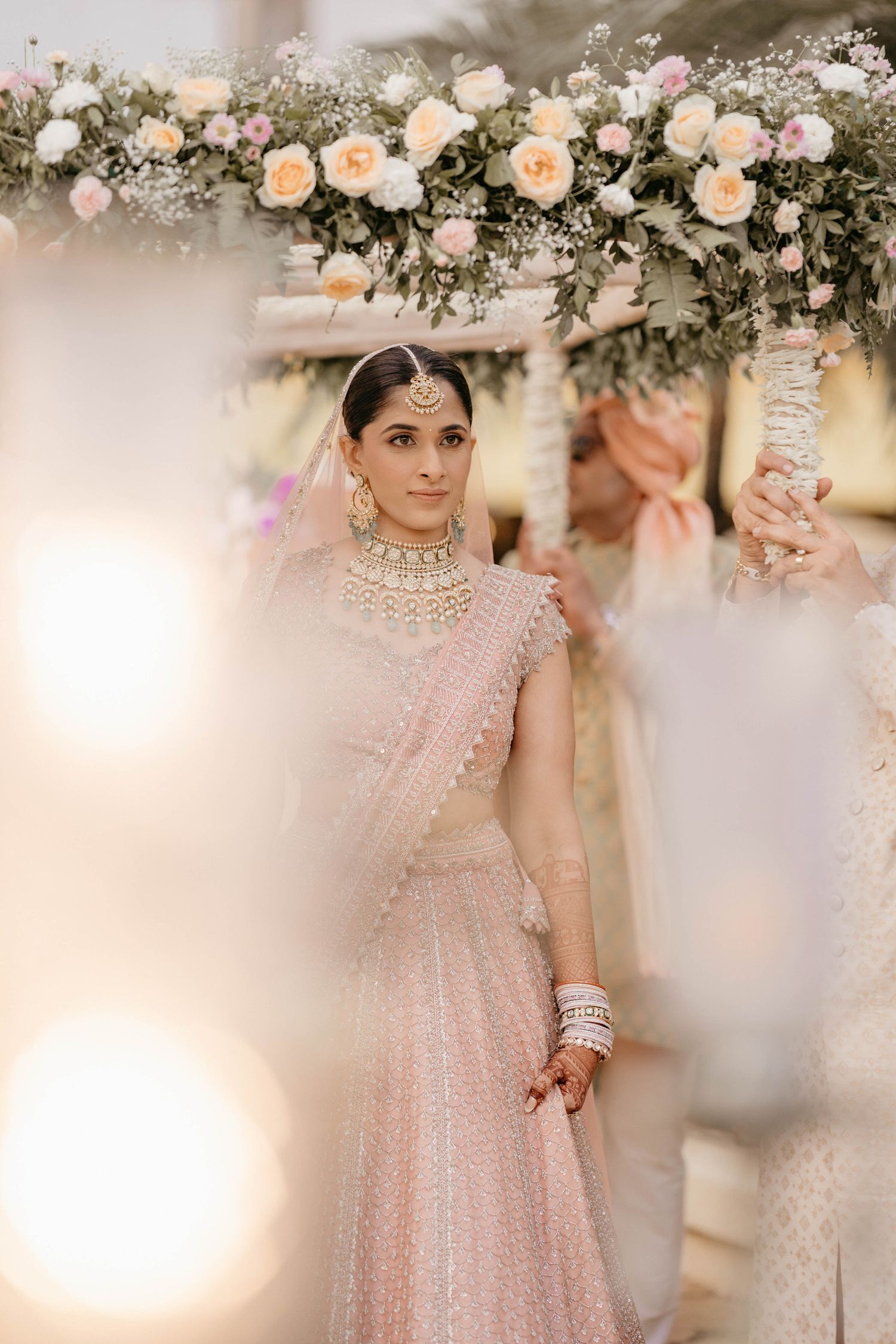 Elegant bridal scene with peach roses and baby's breath floral arch decorations creating a romantic ambiance.