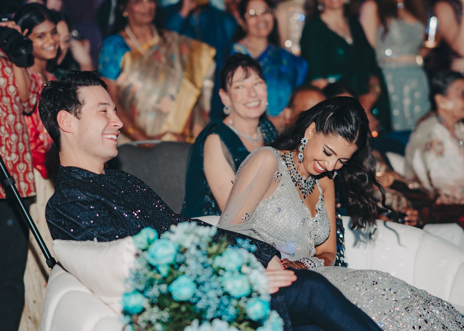 Wedding guests laughing and celebrating during a joyful reception moment.