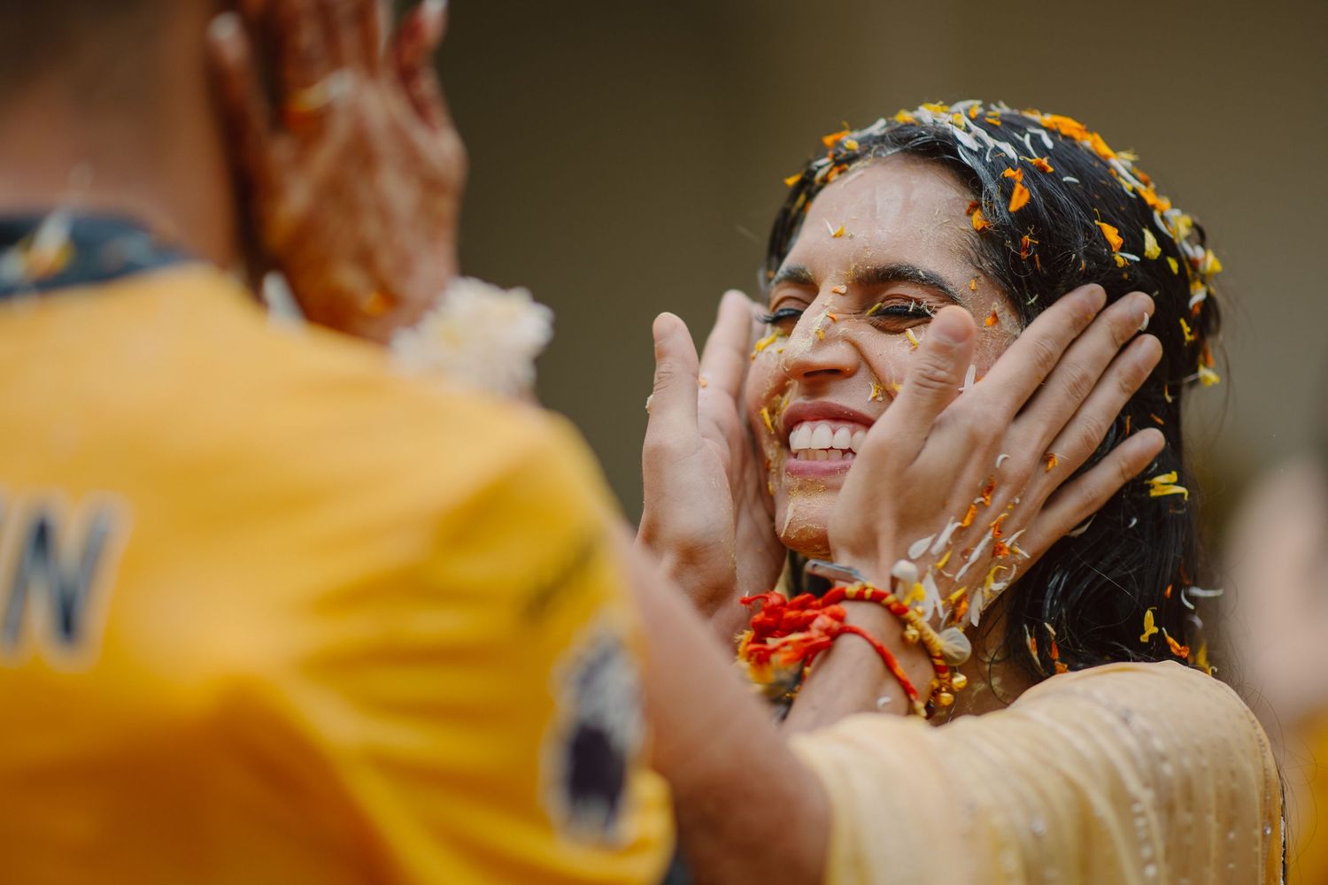 Candid moments captured during a festive wedding celebration with yellow decor.
