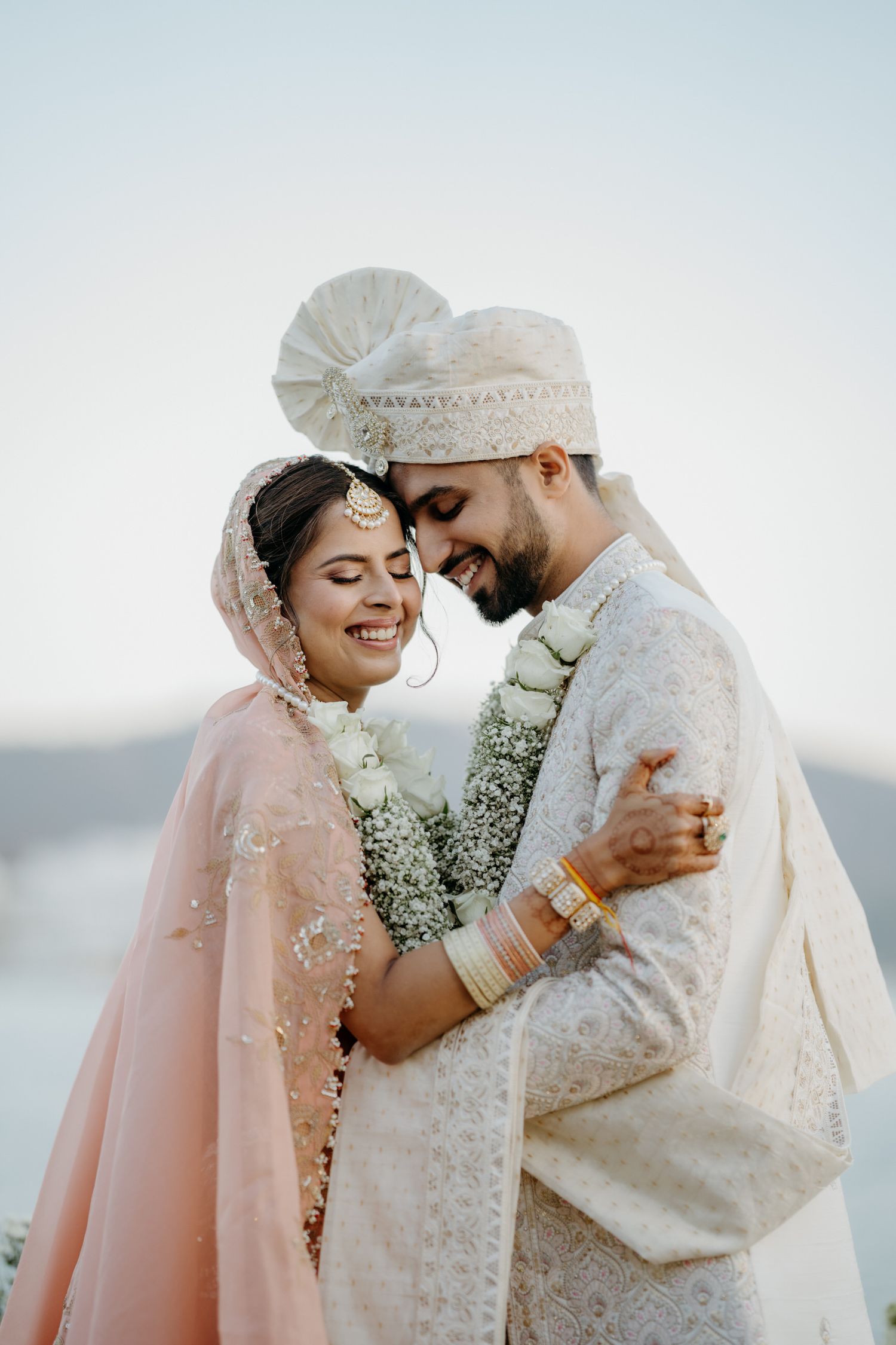 Romantic beachside wedding moment with couple in traditional Indian attire.