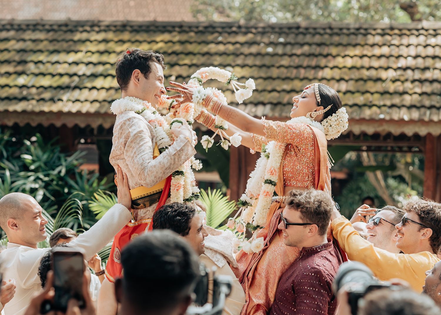 Festive outdoor celebration with guests throwing confetti in the air.