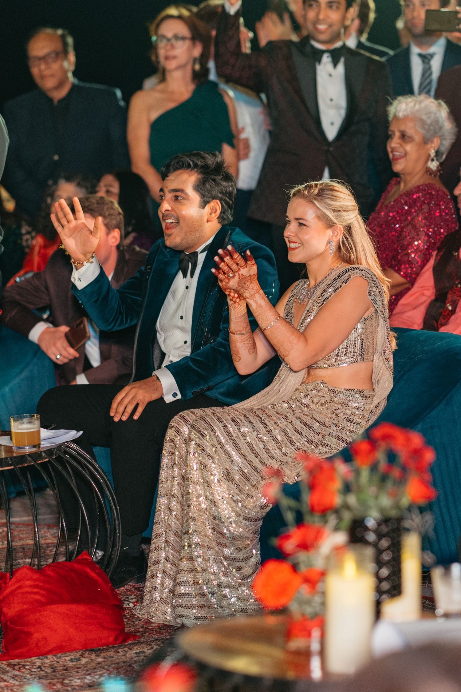 Wedding guests laughing and enjoying entertainment at a formal reception.