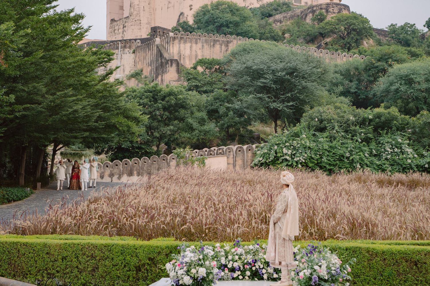 Scenic outdoor wedding venue with stone architecture and lush greenery in background.