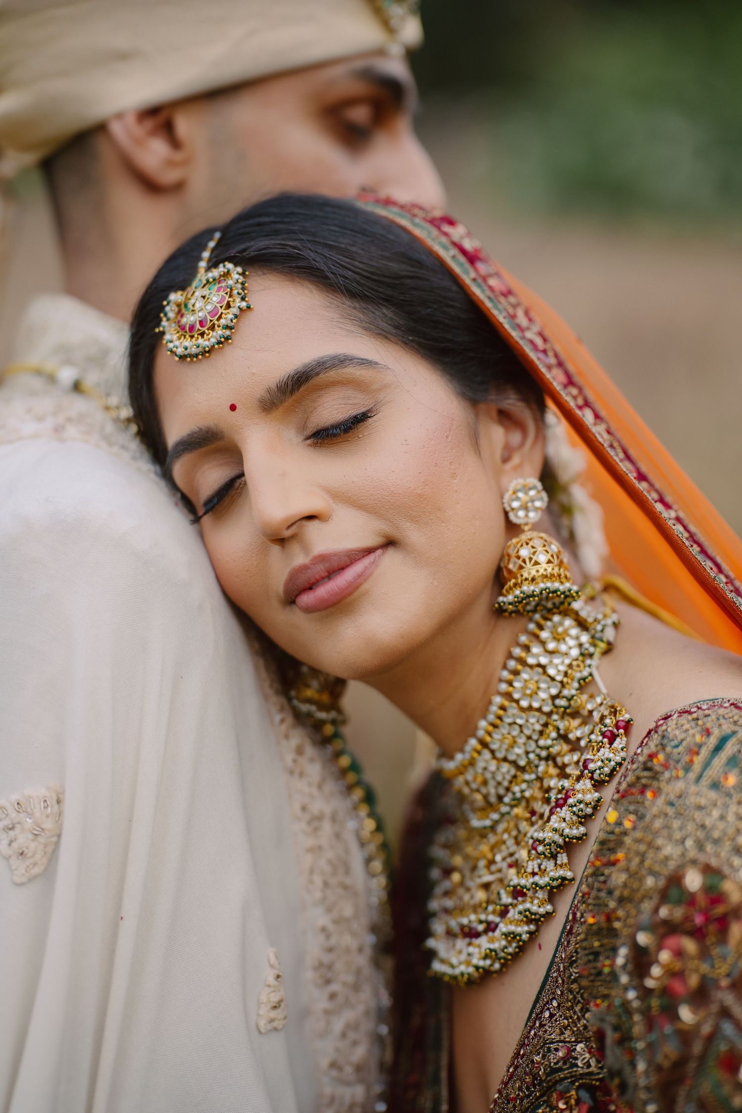 Close-up of intricate bridal jewelry and makeup details in traditional Indian wedding style.