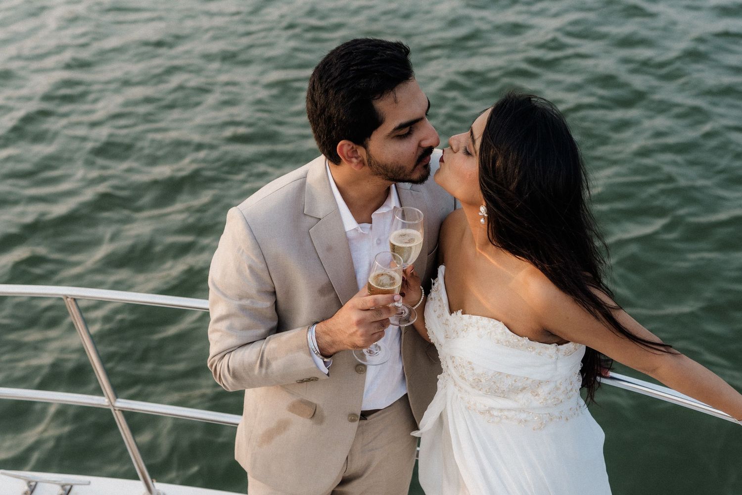 Happy couple celebrating with champagne on a boat during a Goa pre wedding shoot, candidly photographed by Studio RDP