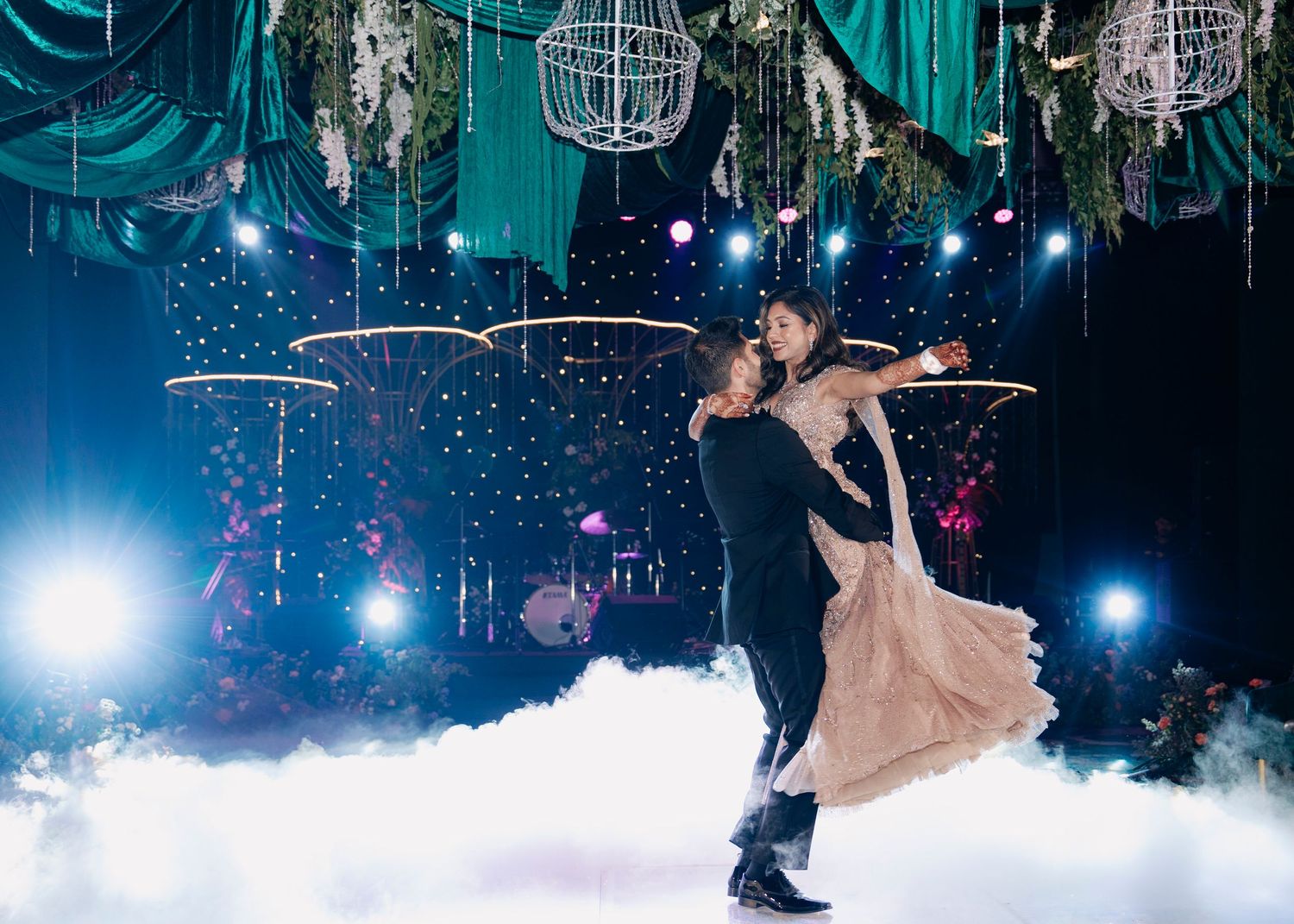 A festive ballroom dance scene with glittering chandeliers and swirling dancers under blue spotlight illumination.