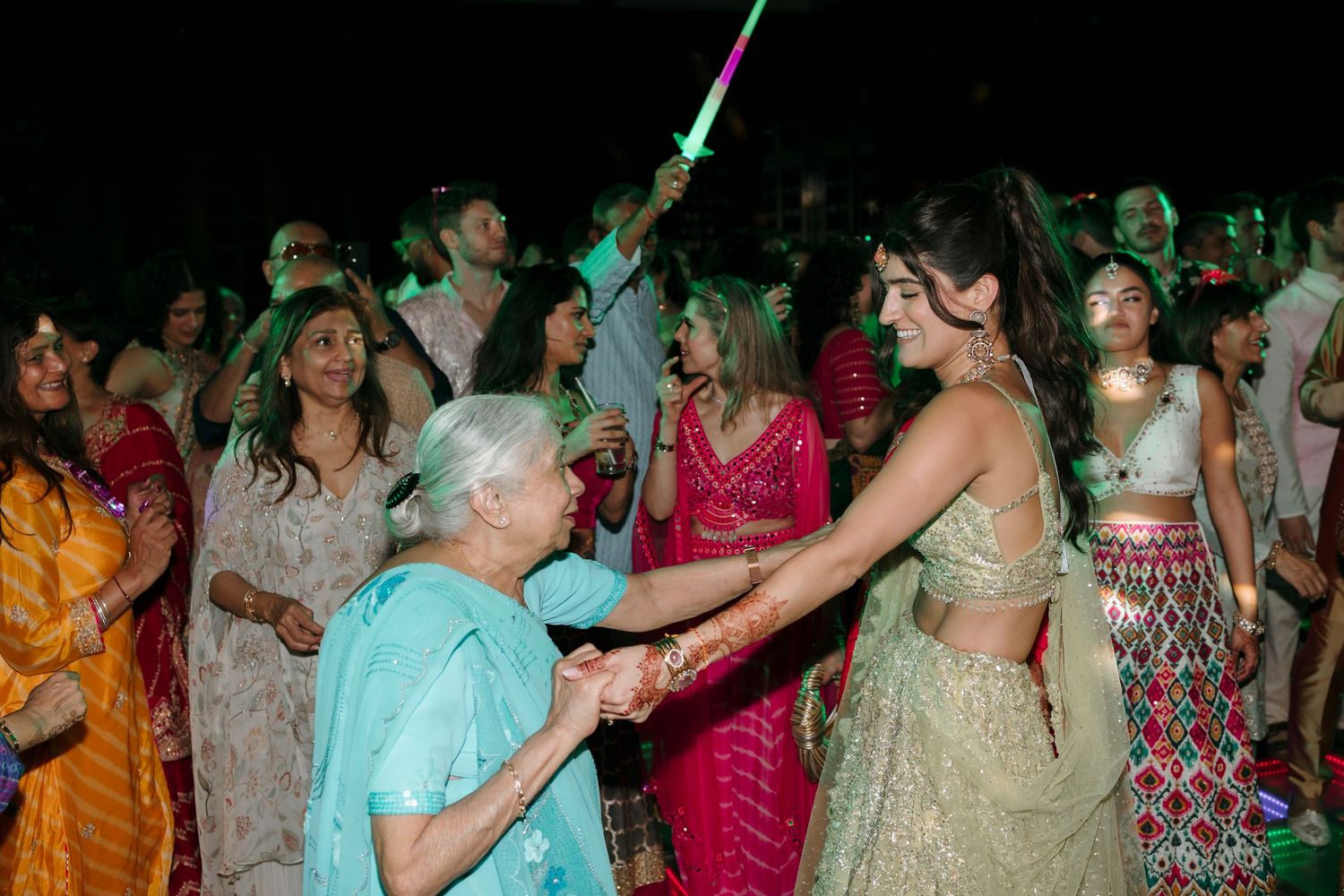 Large group of people dancing together at a festive celebration event with colorful traditional clothing.