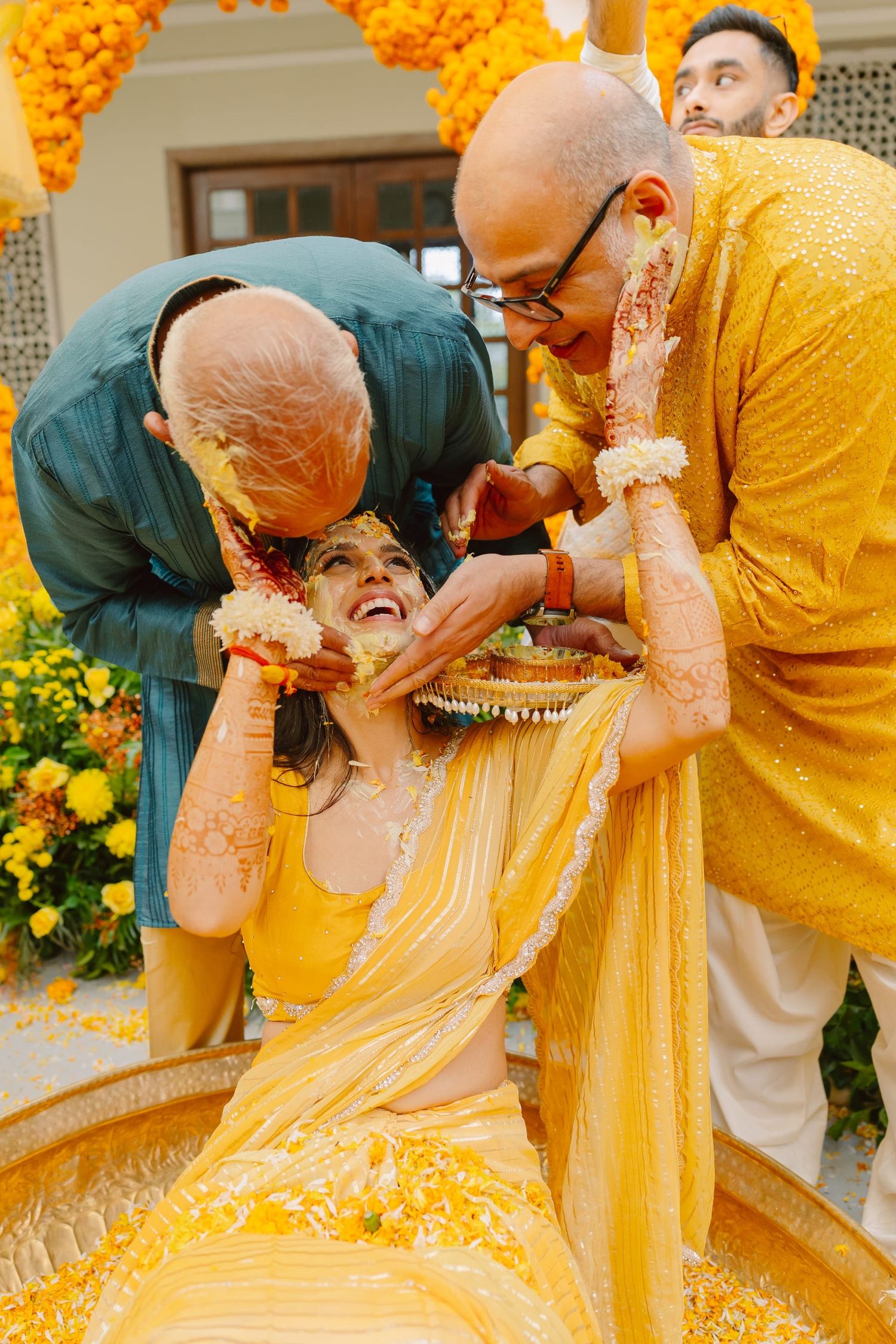 Traditional haldi ceremony with yellow turmeric being applied during wedding rituals.