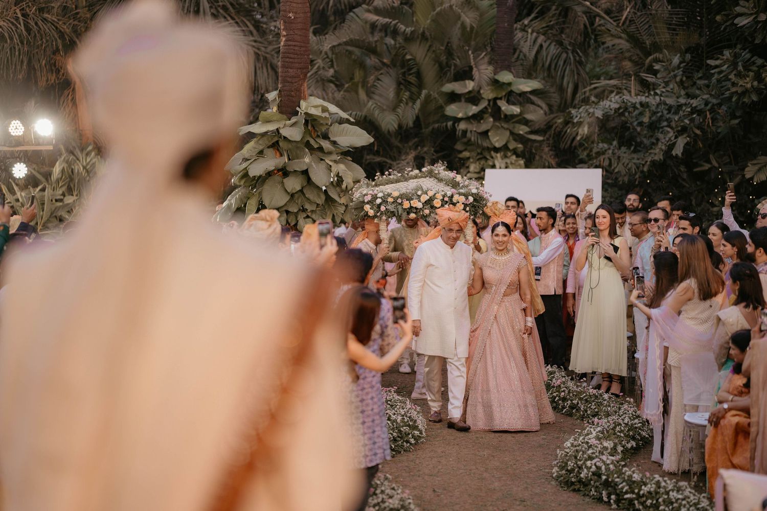 Wedding guests shower the happy couple with confetti during an outdoor garden ceremony celebration.