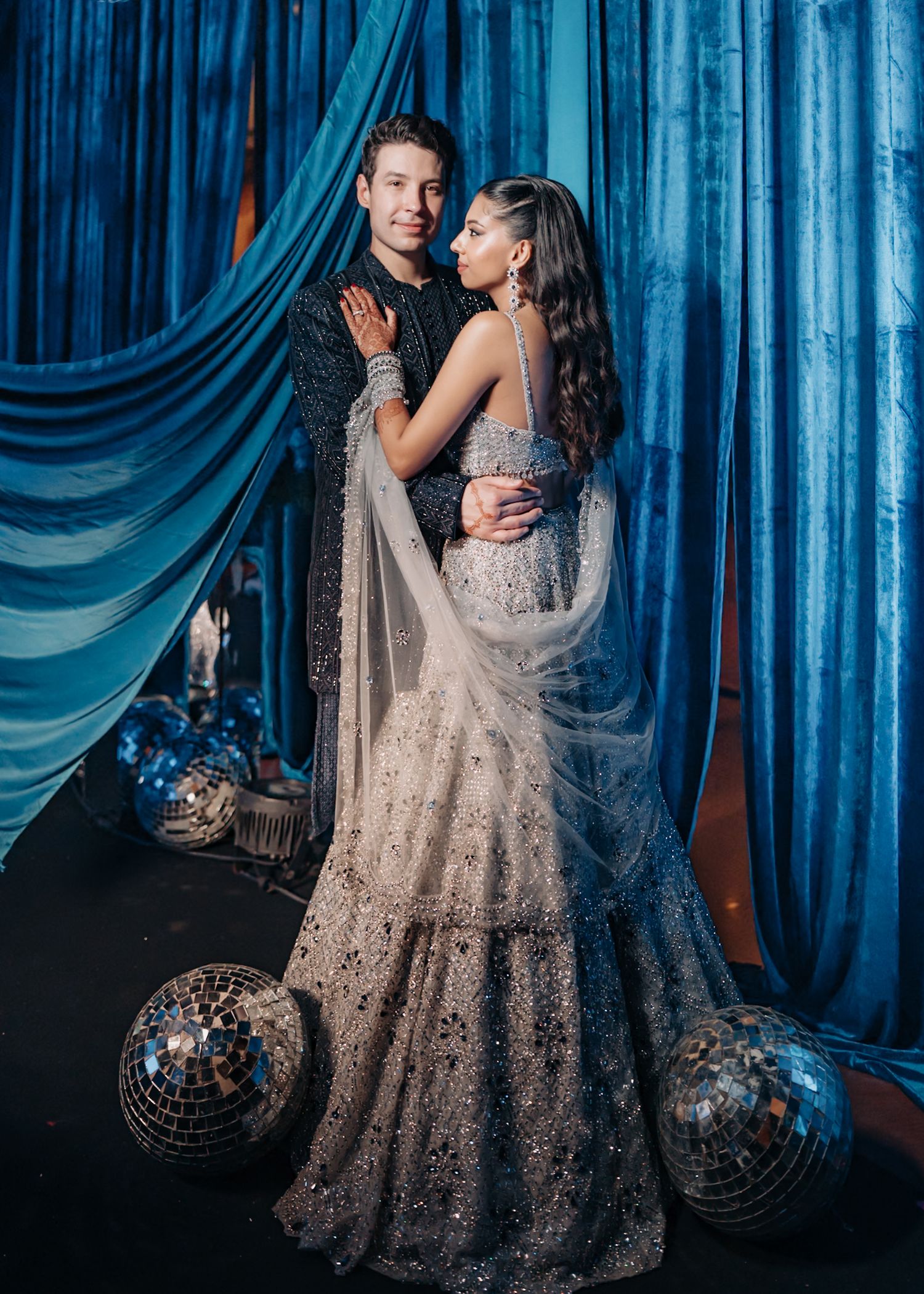Romantic wedding portraits against blue draped backdrop with disco balls.