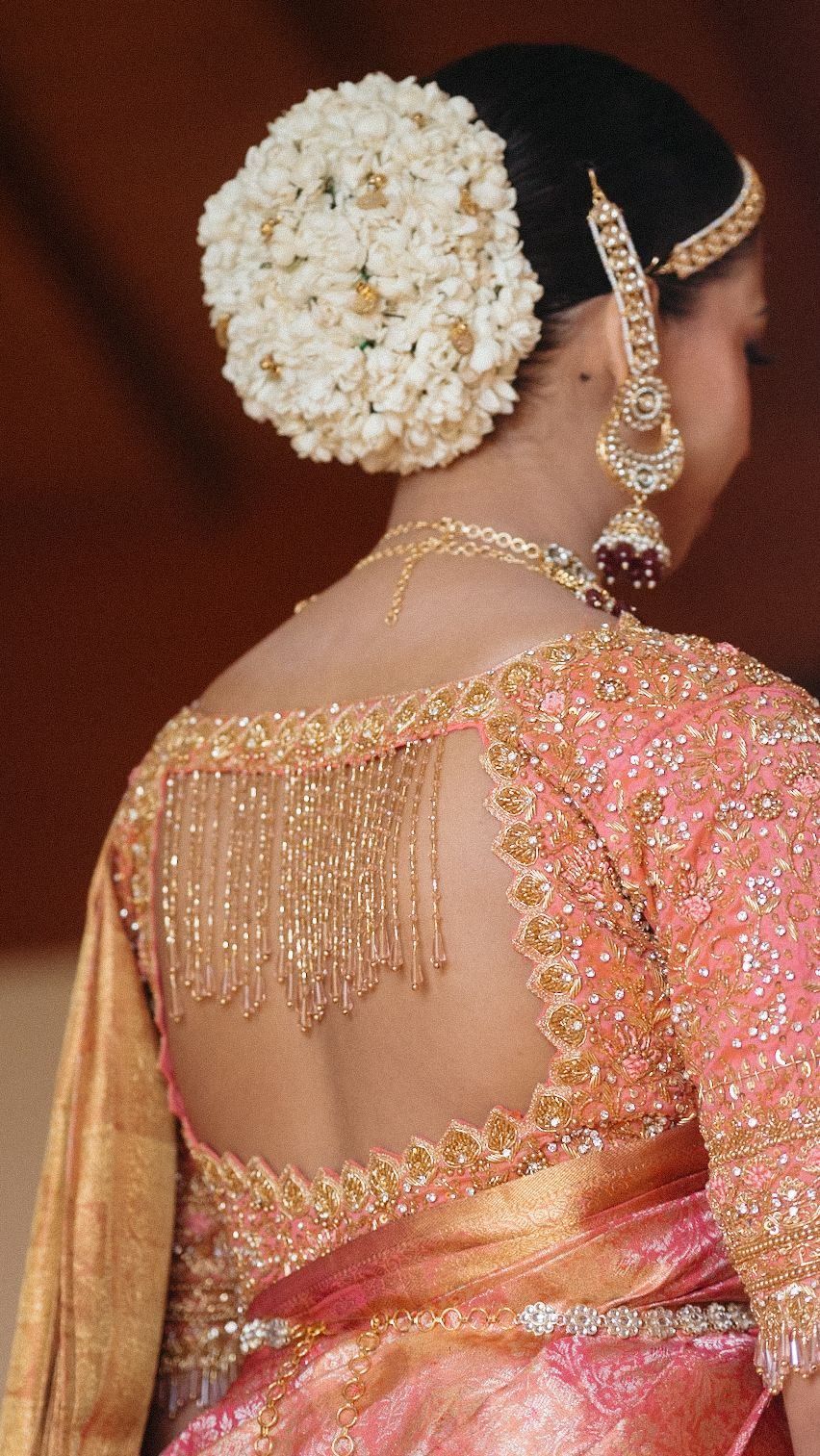Detailed view of intricate beadwork and embellishments on pink and gold South Asian bridal attire.