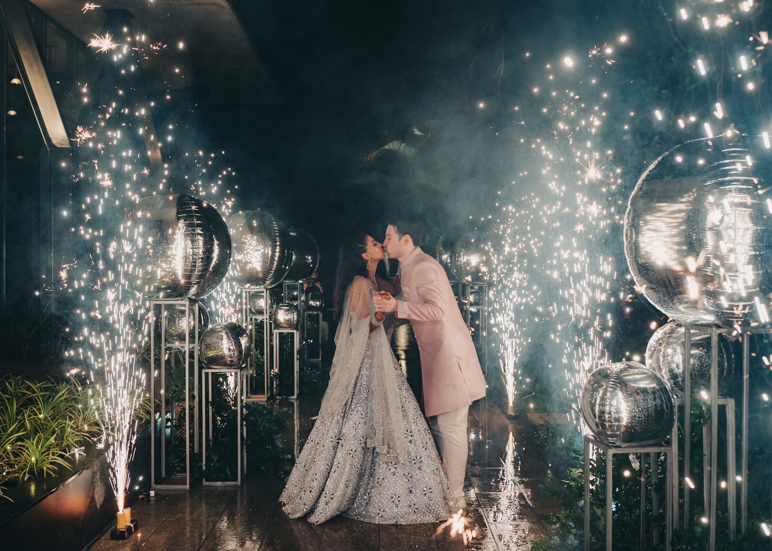 Dramatic nighttime wedding scene with sparklers creating a magical atmosphere.