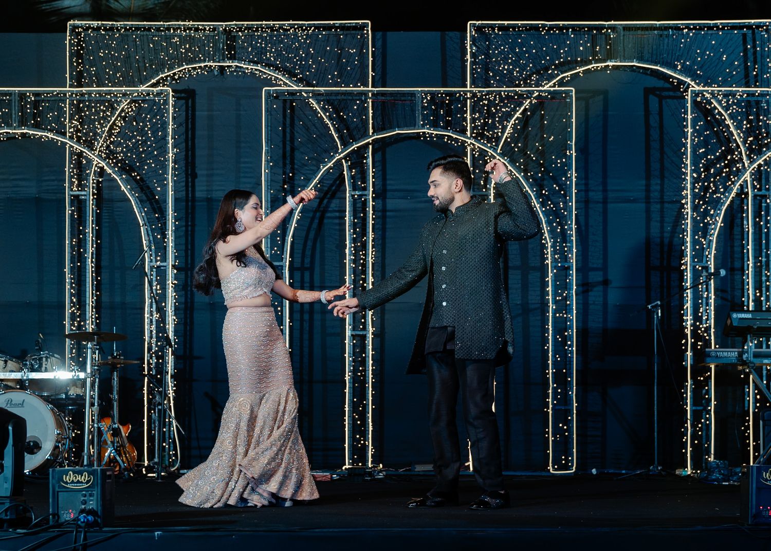A dramatic nighttime scene with illuminated archways and fairy lights creating a magical atmosphere.