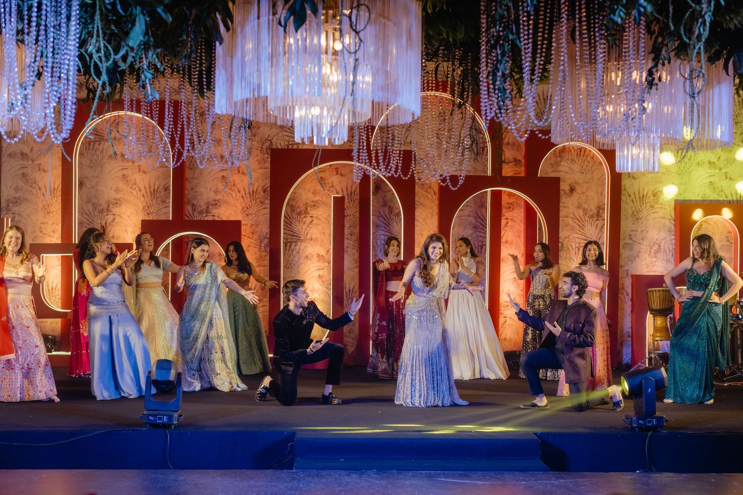 A stage production shows performers in period costumes with ornate lighting and set design creating a magical atmosphere.