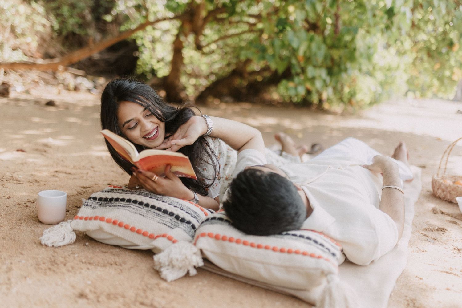 A couple relaxes on cozy floor pillows while reading books together in a tranquil indoor setting.