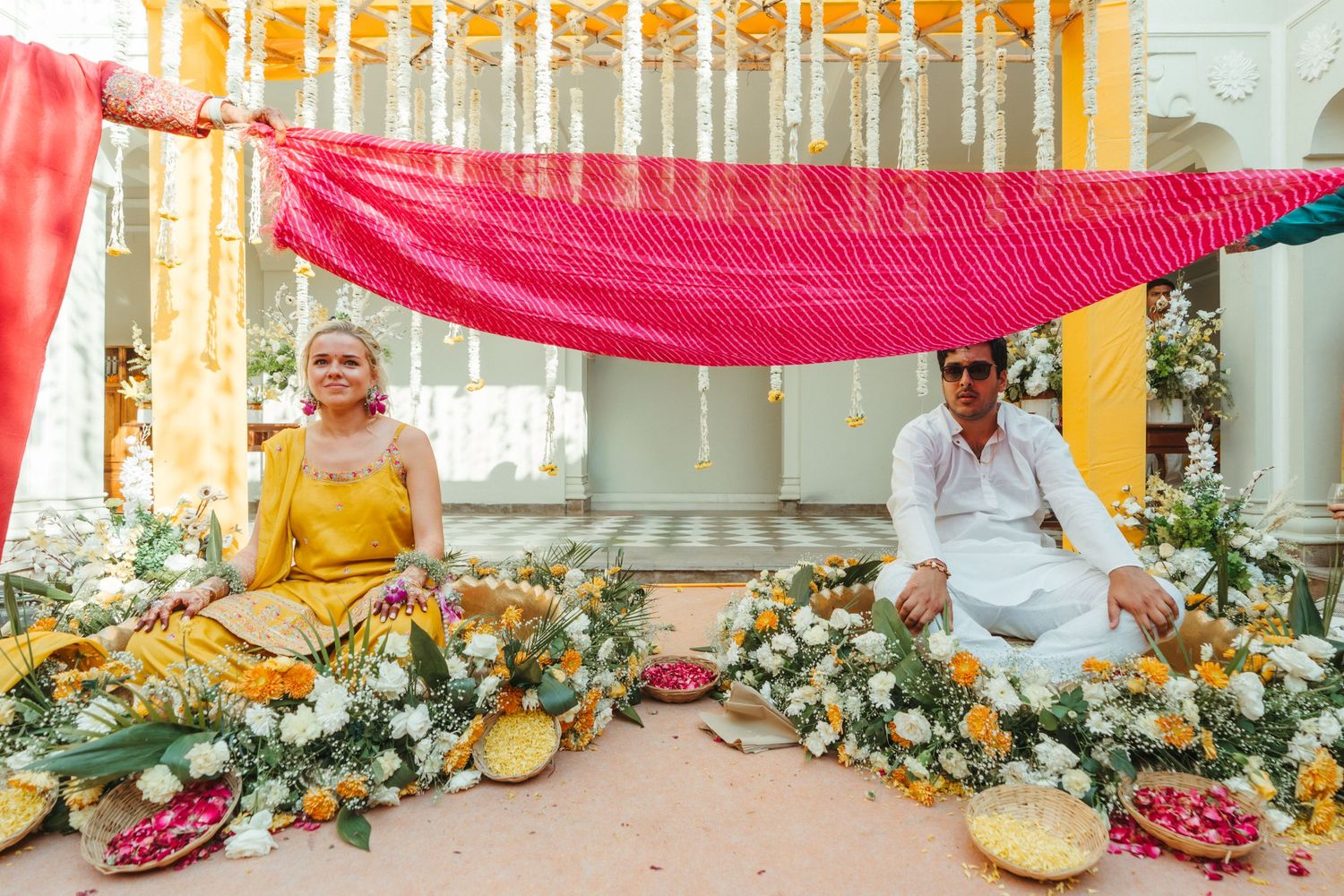 Wedding venue decorated with pink and orange drapes and floral arrangements creating an elegant atmosphere.