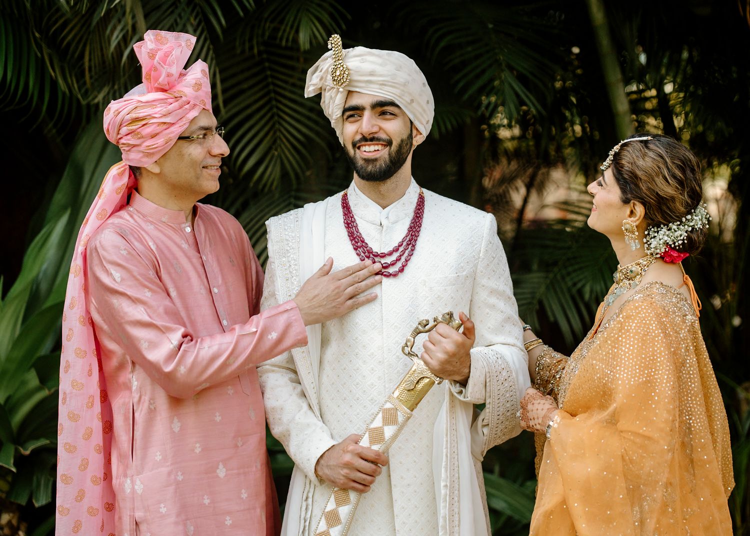 Traditional Indian wedding attire featuring pink and white outfits with elegant accessories and decorations.