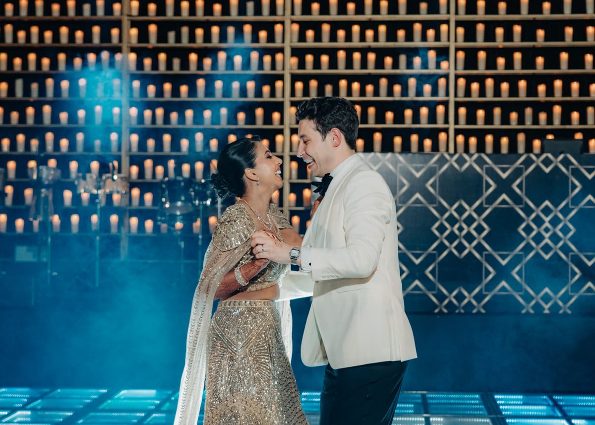 A romantic dance sequence on an illuminated dance floor with geometric patterns in the background.