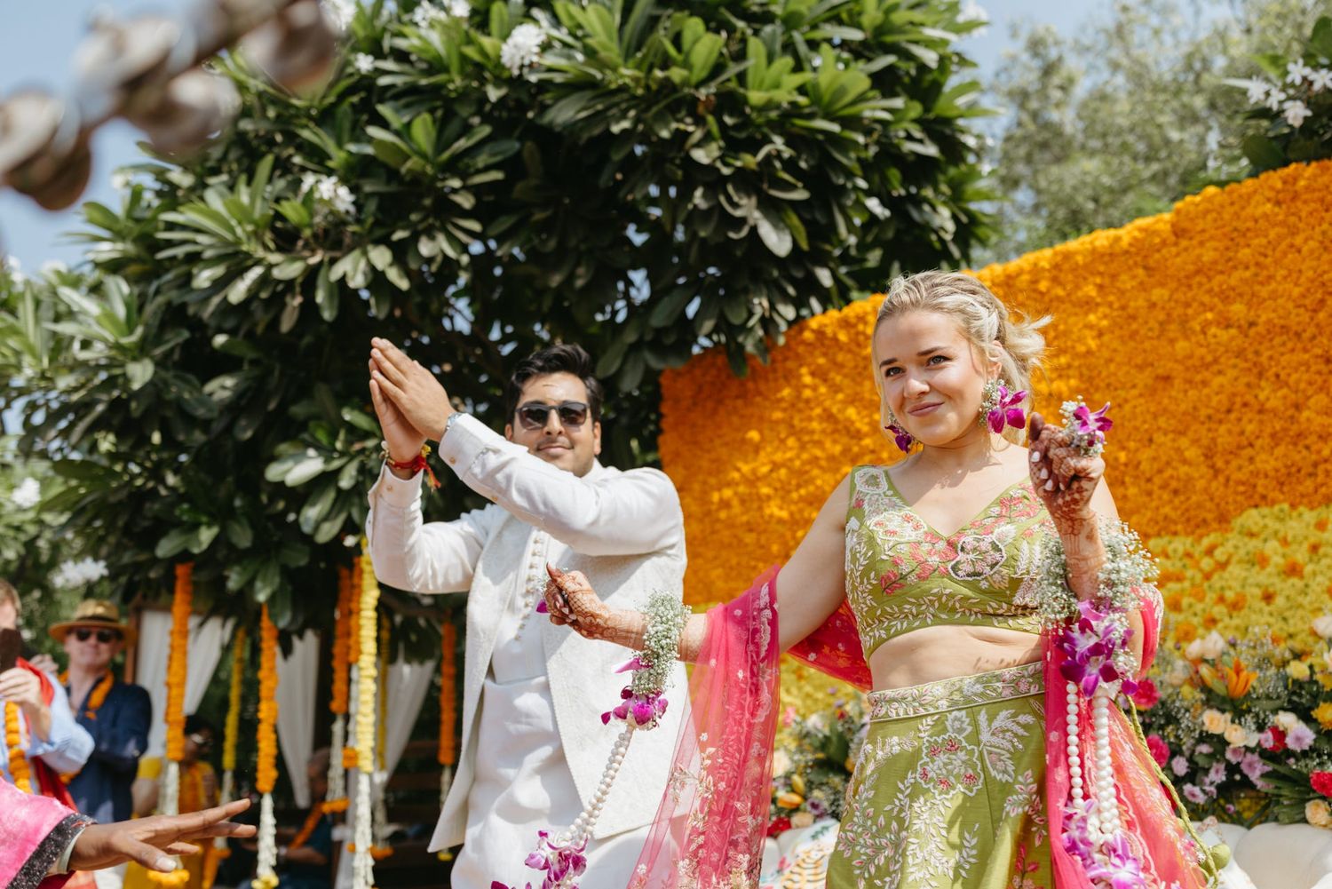 Outdoor wedding venue decorated with marigold flowers and greenery creating a stunning backdrop.