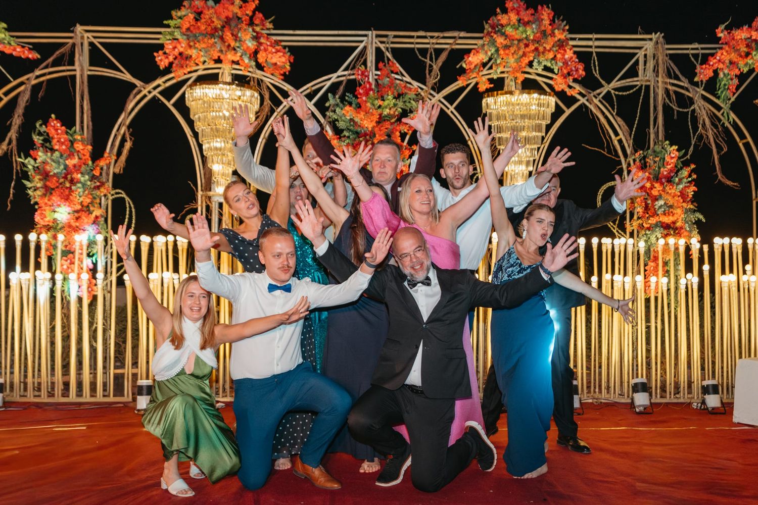 Guests celebrating at a wedding reception with bamboo decor and autumn-themed floral arrangements.