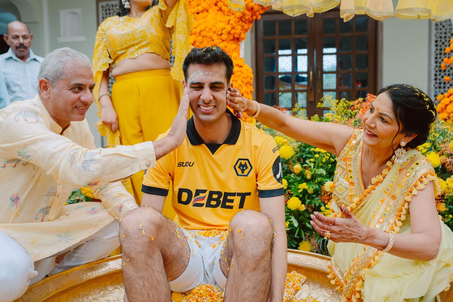 Traditional Indian wedding ceremony with bright marigold decorations and yellow-themed outfits.