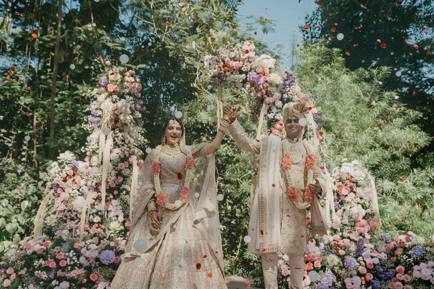 Garden wedding photoshoot with floral arrangements and natural greenery backdrop.