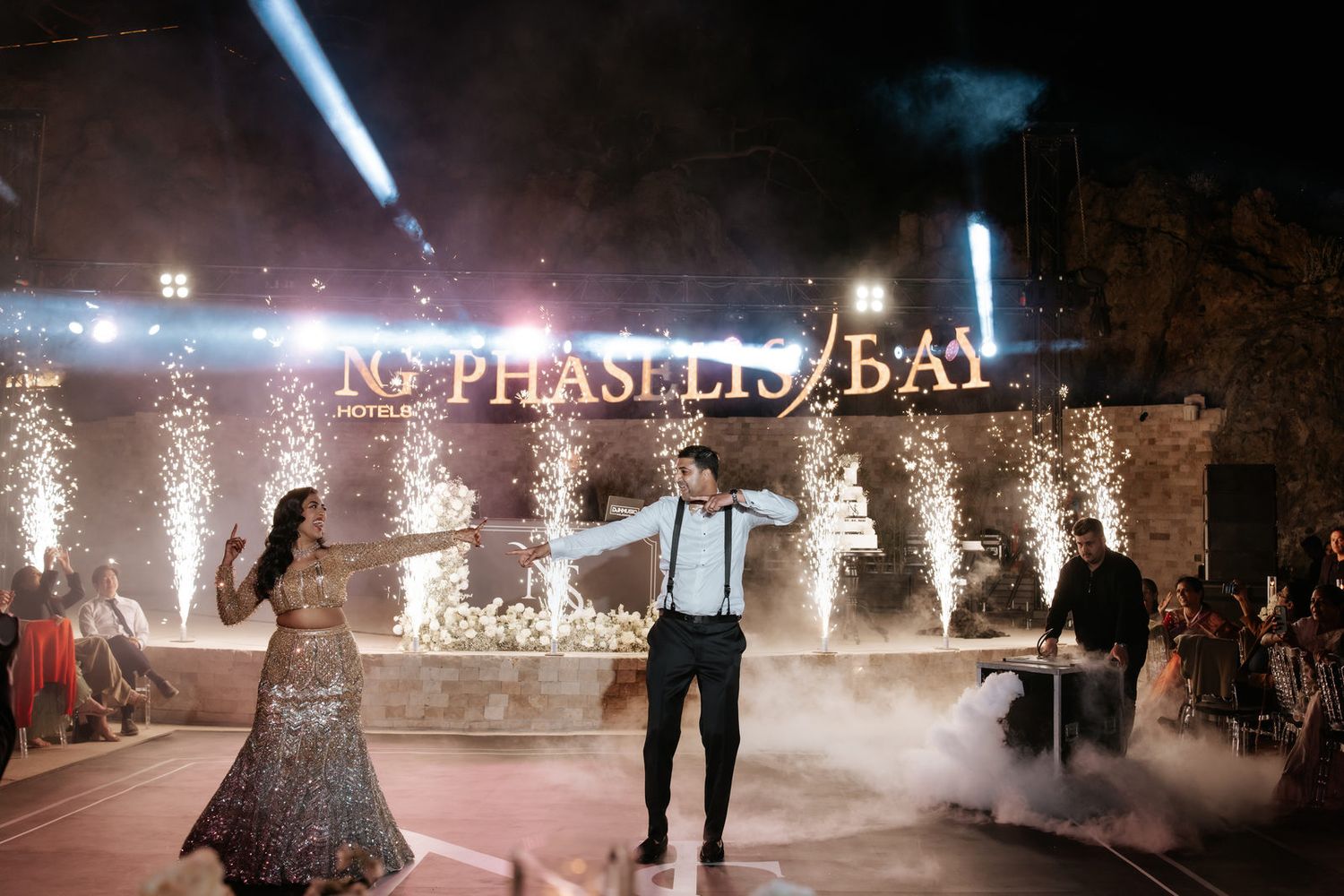 Couple shares first dance at Phaselis Bay wedding venue with dramatic fog effects and sparkling light backdrop at night.