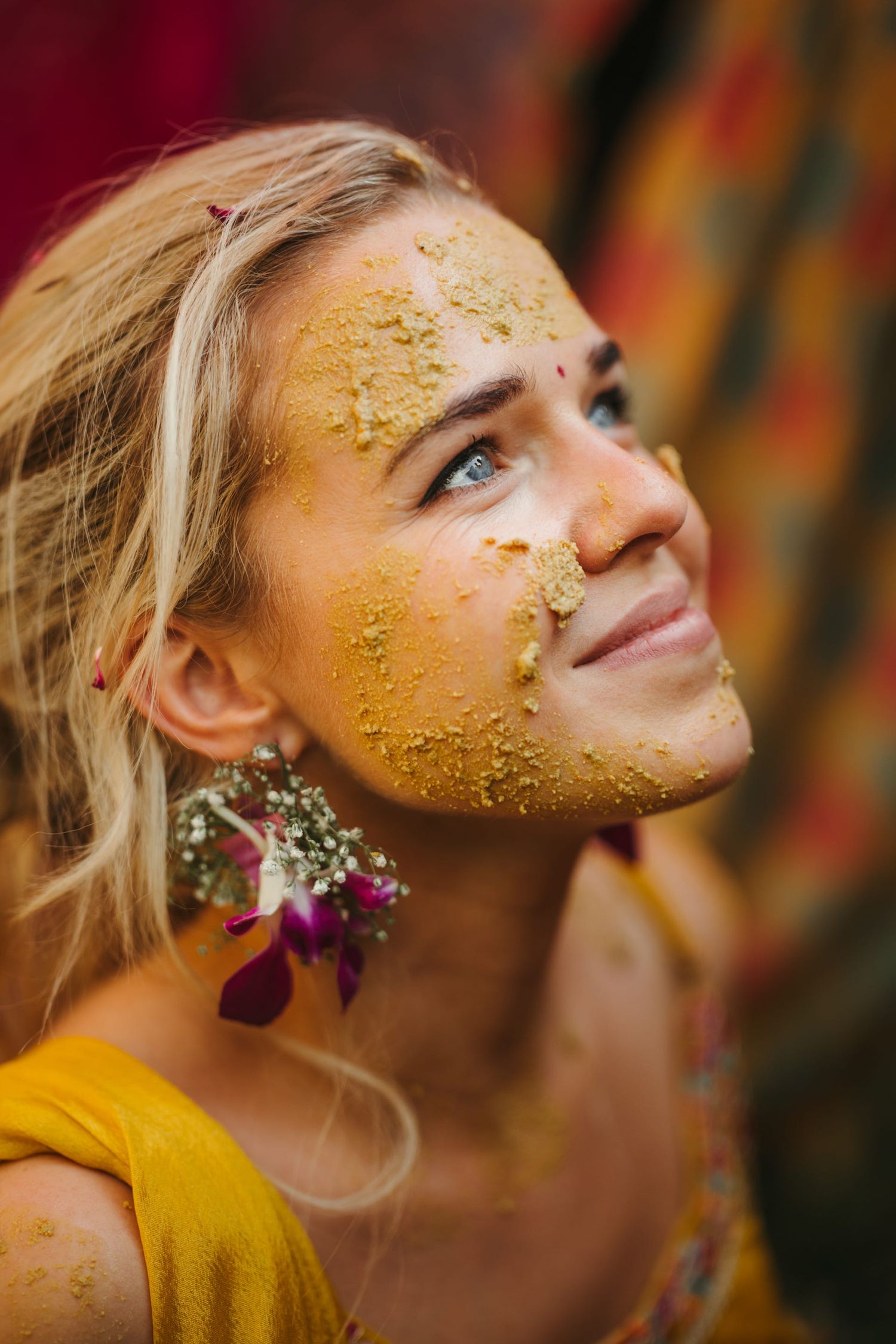 Close-up shot showing yellow turmeric powder and floral decorations during a traditional ceremony.