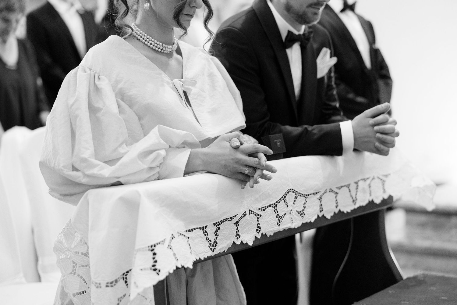 Wedding ceremony guests reading from white papers during an indoor celebration.